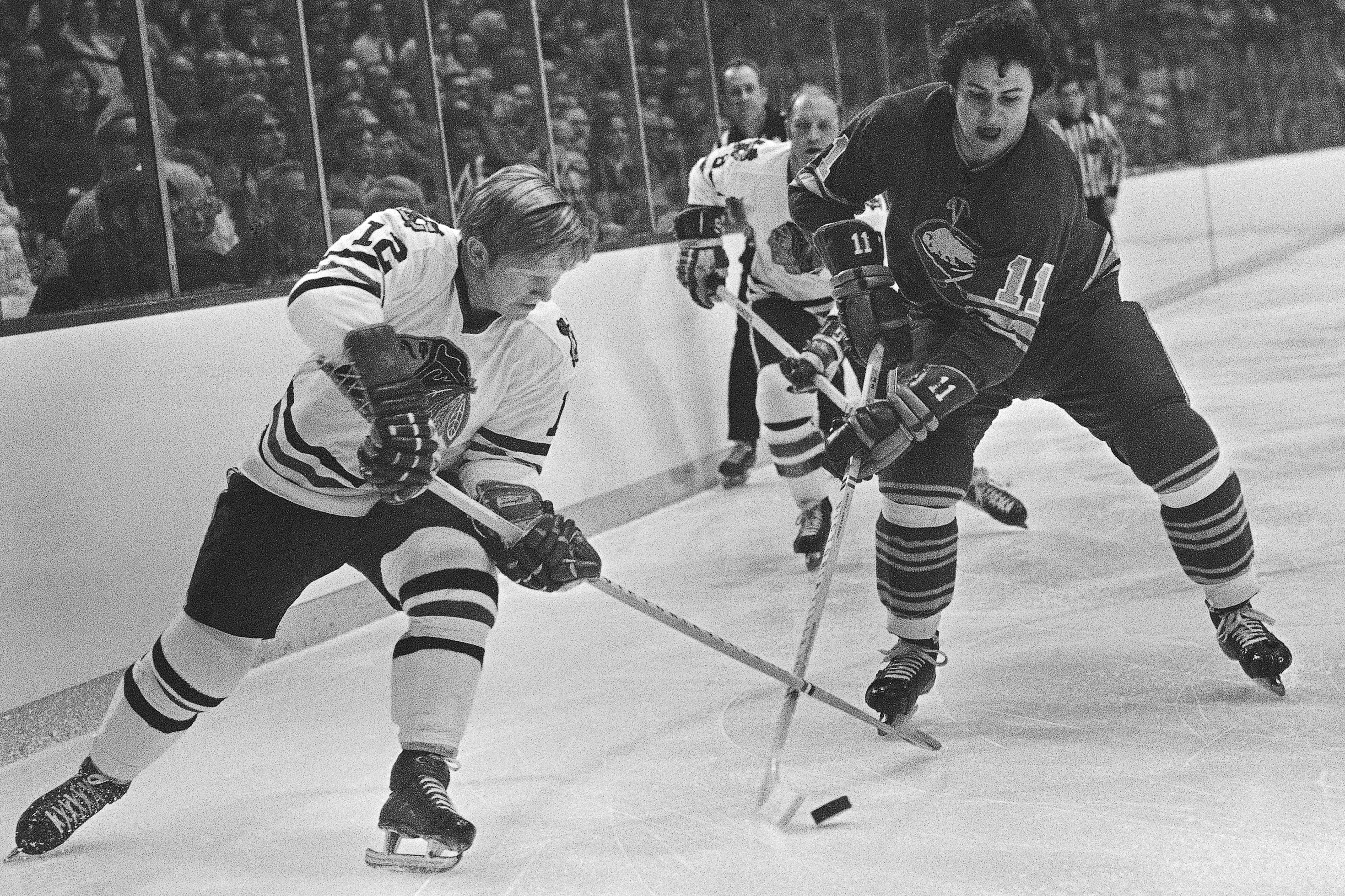 Pat Stapleton (left) battles Buffalo's Gilbert Perreault for the puck during a 1971 game.
