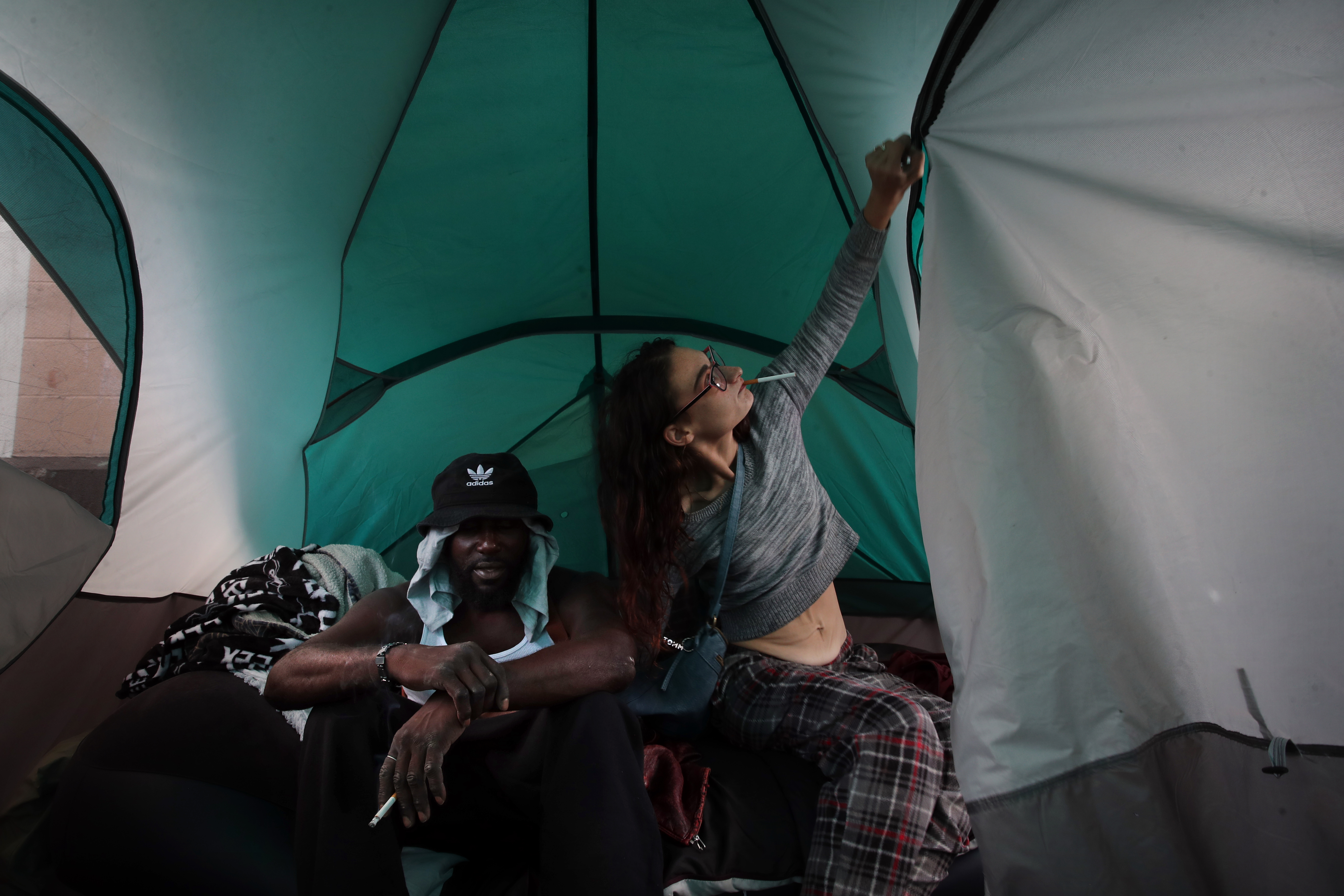 Emily (right) closed the tent while sitting with her partner, who goes by the name Magic, on Topeka Street.