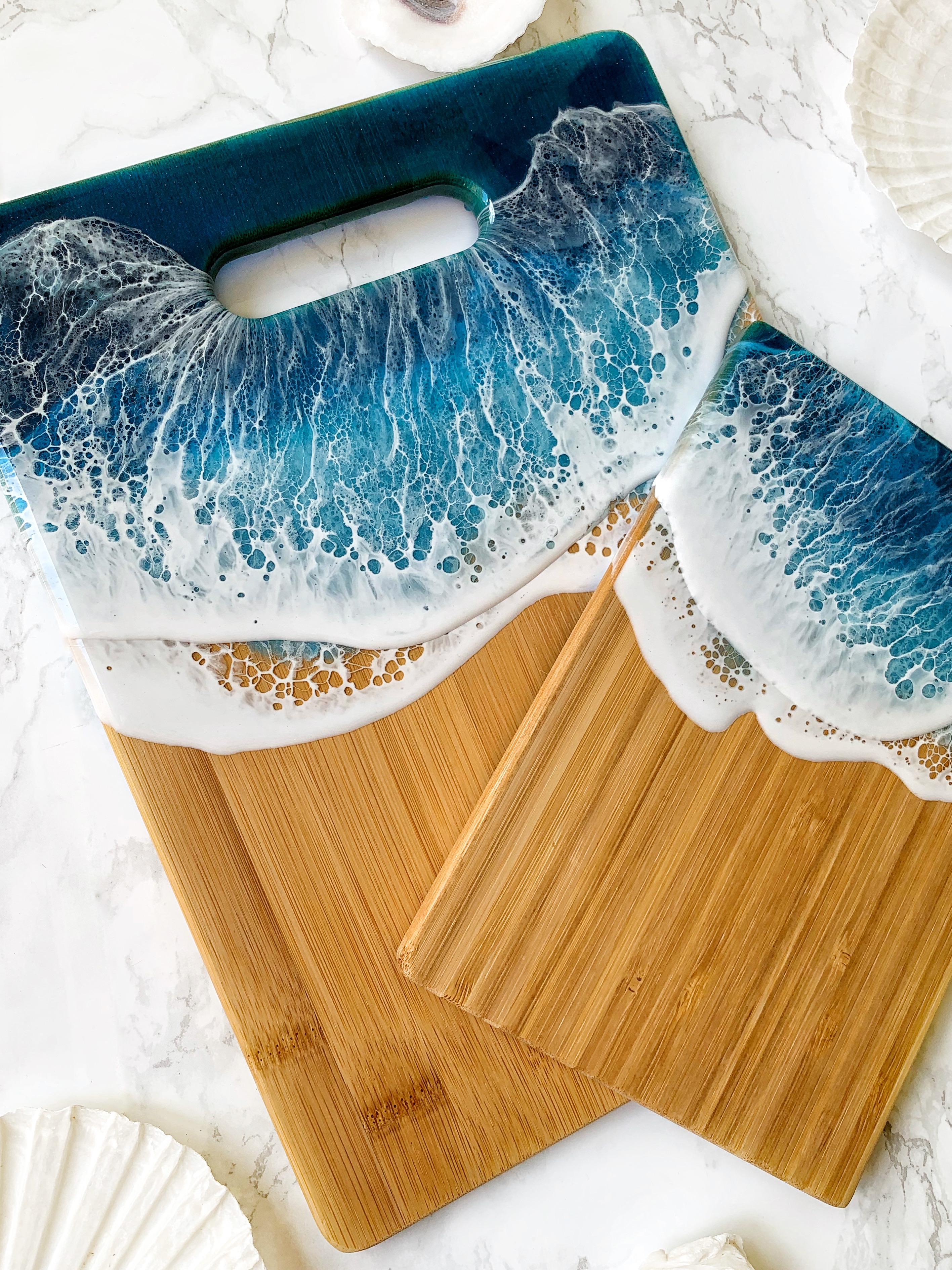 Salt + Shimmer Artistry serving boards crafted with designs made with resin that evoke a ripple of waves washing ashore.