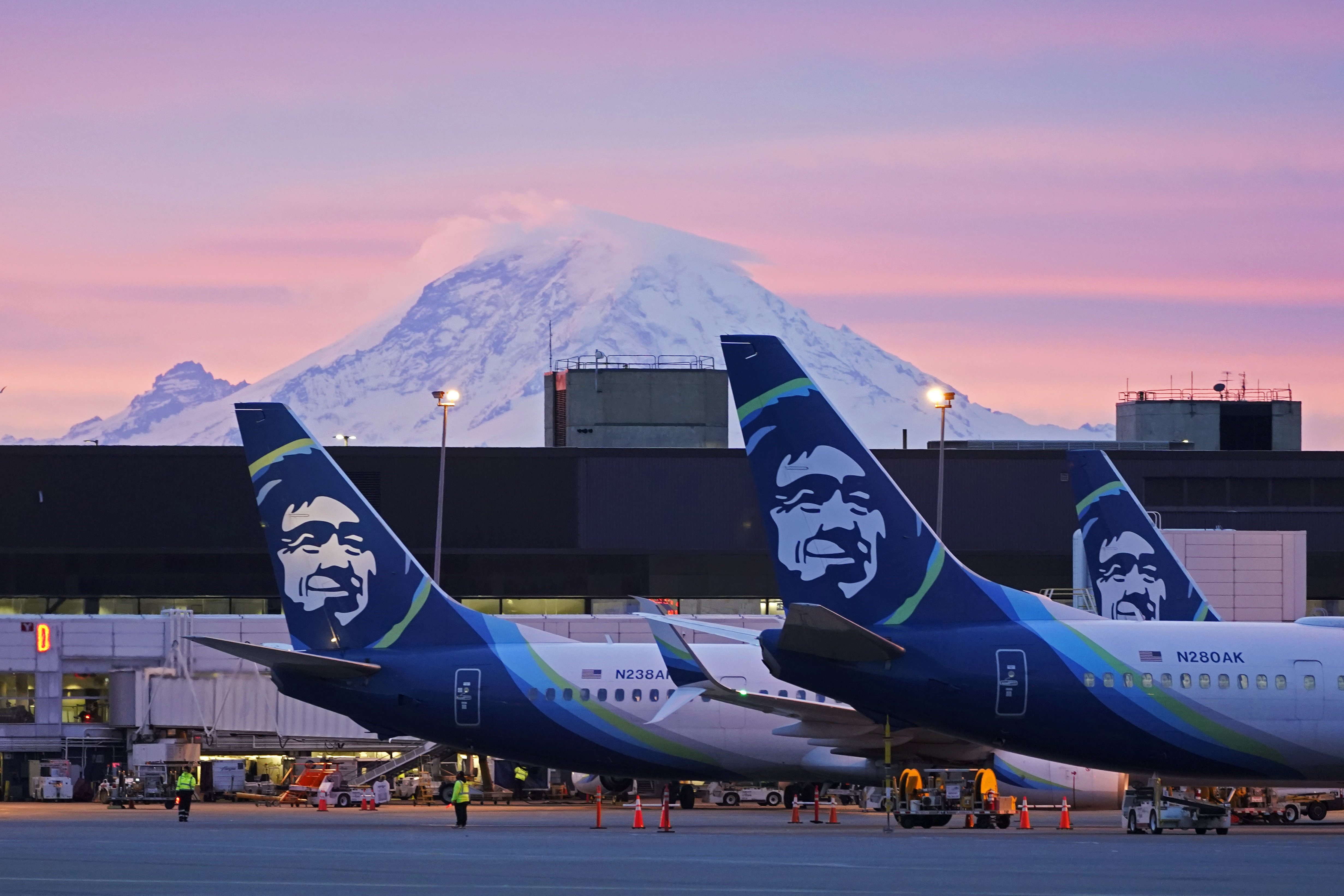 Alaska Airlines planes are shown with Mount Rainier in the background at sunrise at Seattle-Tacoma International Airport earlier this year. One way to sidestep cancellations is to book the first flight of the day.