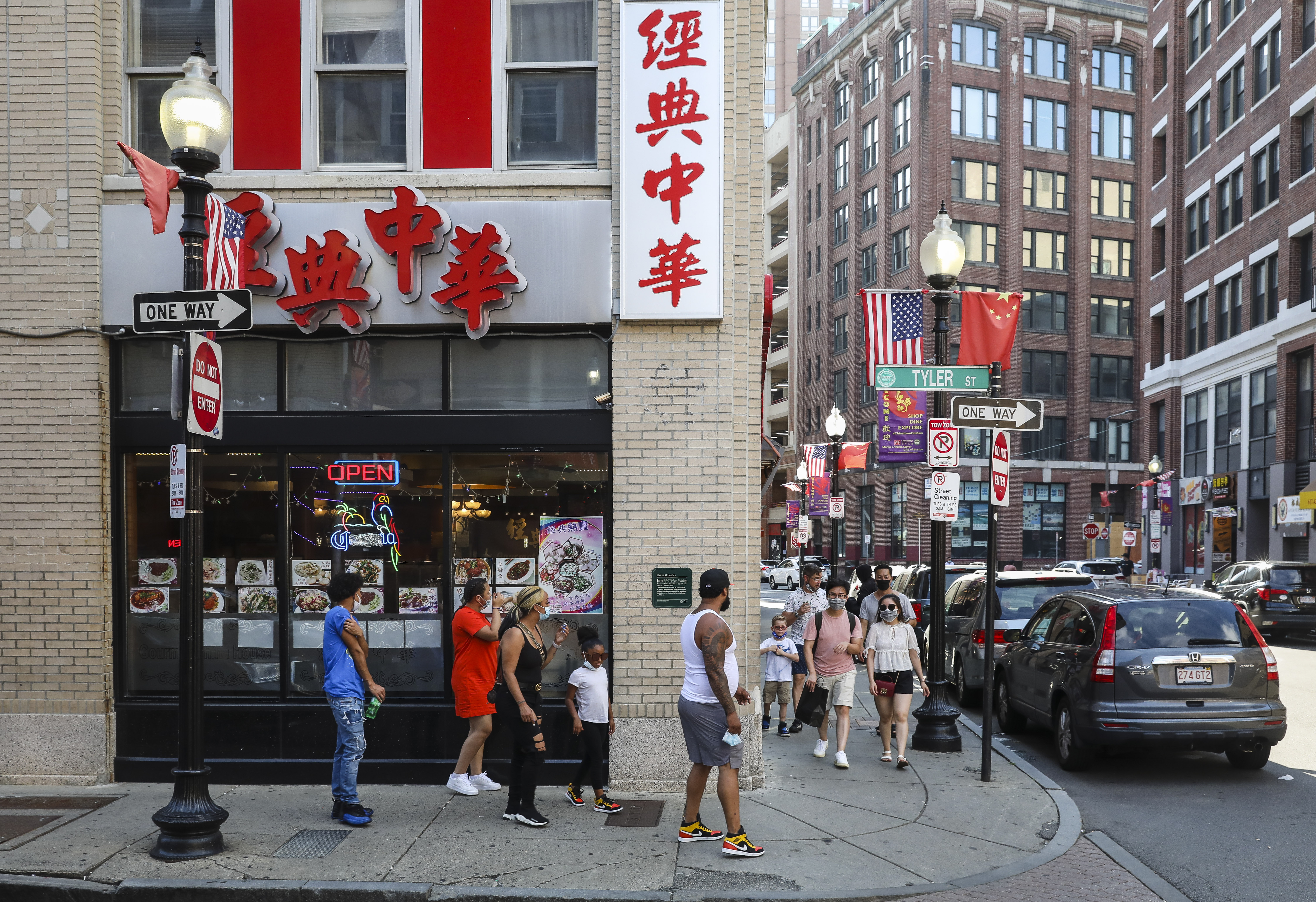 People walk past the exterior of Gourmet China House in Chinatown. The restaurant has erected clear plastic partitions between tables to protect employees and customers from the spread of COVID-19.