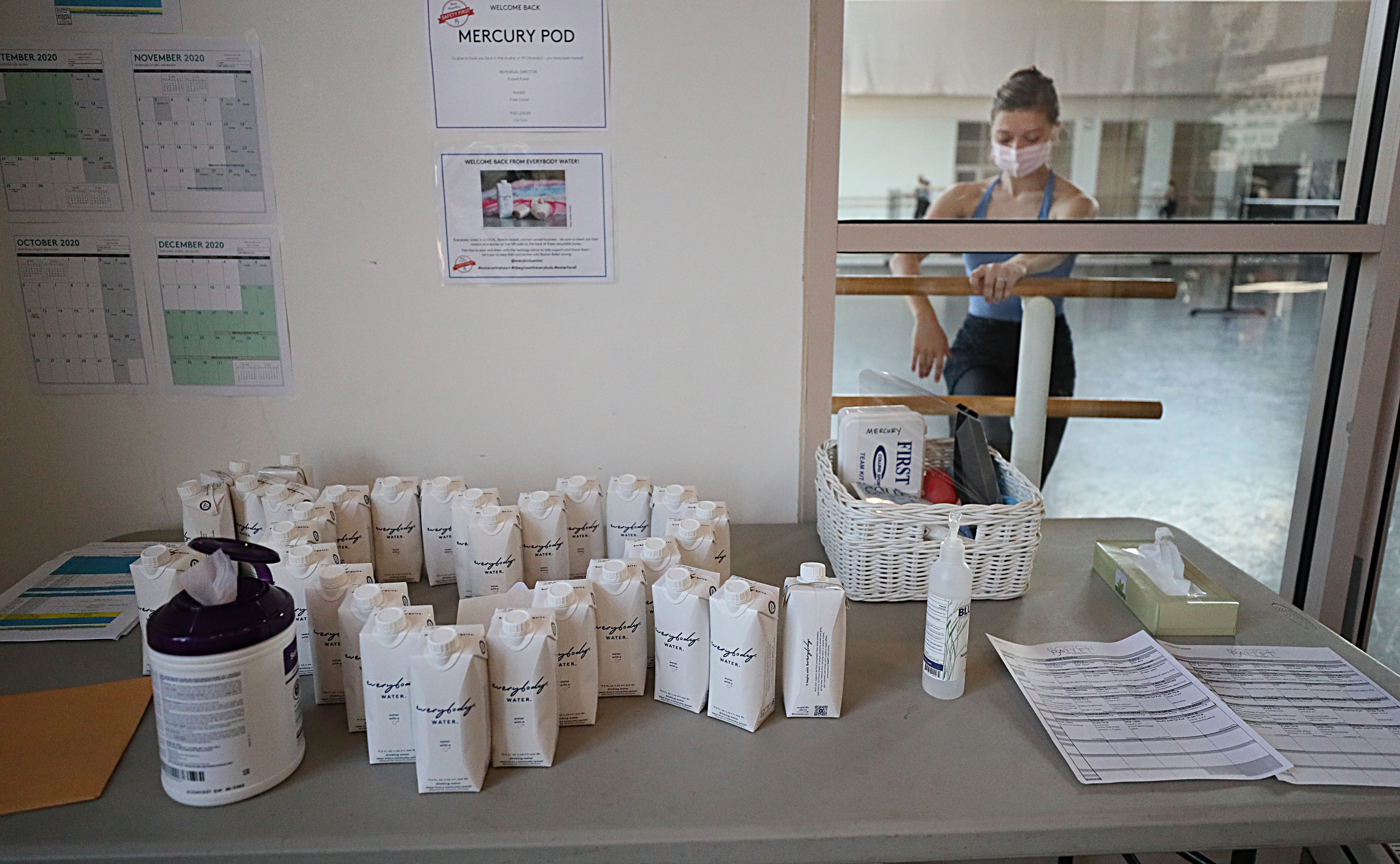 Ryan Kwasniewski attends Company class in the "Mercury Pod" studio at Boston Ballet; hand sanitizer and wipes are set up outside.