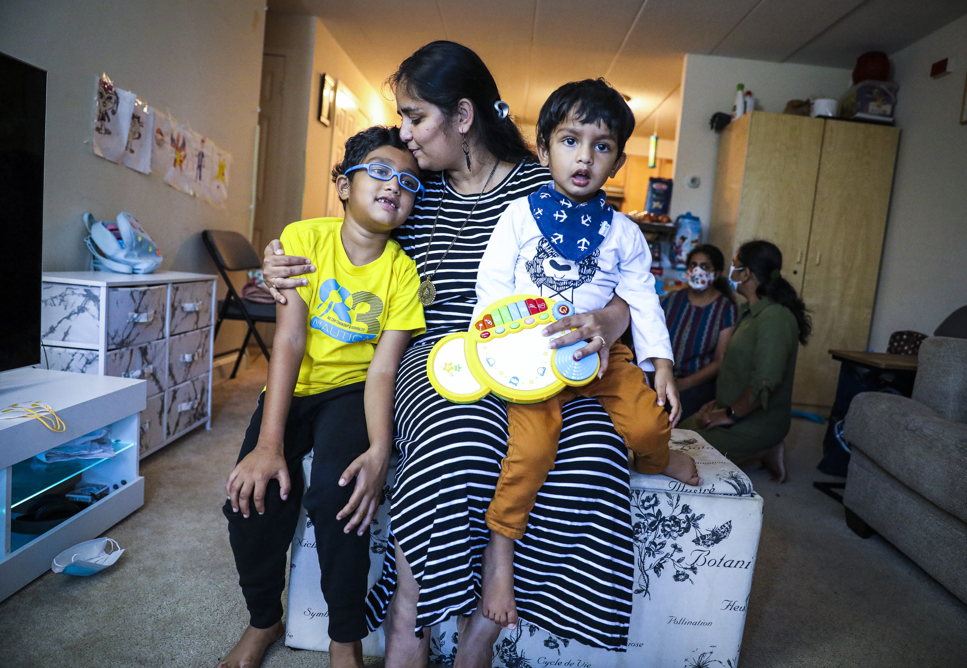 Priyanka Rajoria held her 2-year-old son Niam while she kiseed her 7-year-old son Akshin as they spent the afternoon in their Quincy apartment.