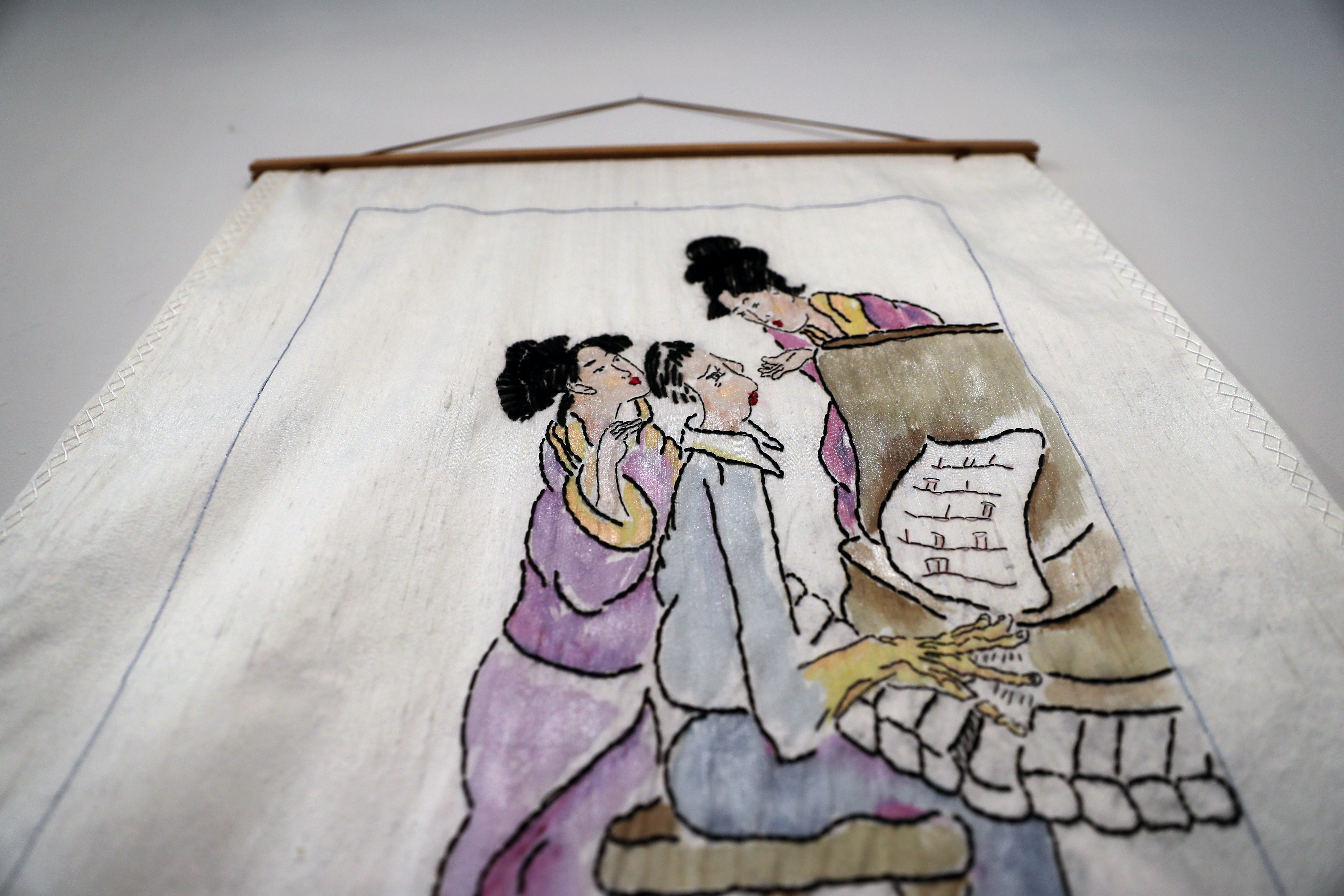Artist Carol Scavotto's artwork is on display in the gallery. This piece is for sale for $2,500. It is mounted top and bottom on teak bars with white dupioni silk fabric, silk threads, and silk mohair.