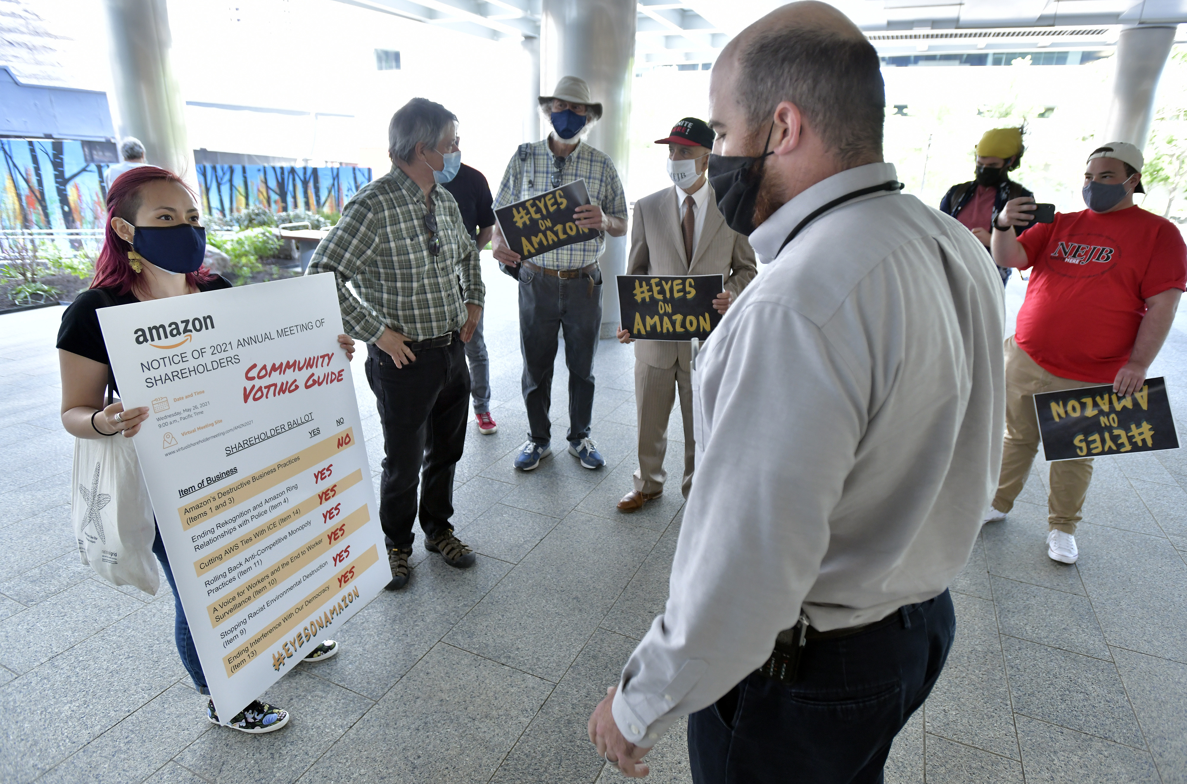 Yessenia Prodero of Jobs with Justice and representatives of other worker groups present a blown-up ballot to Brian Clement of Fidelity security.