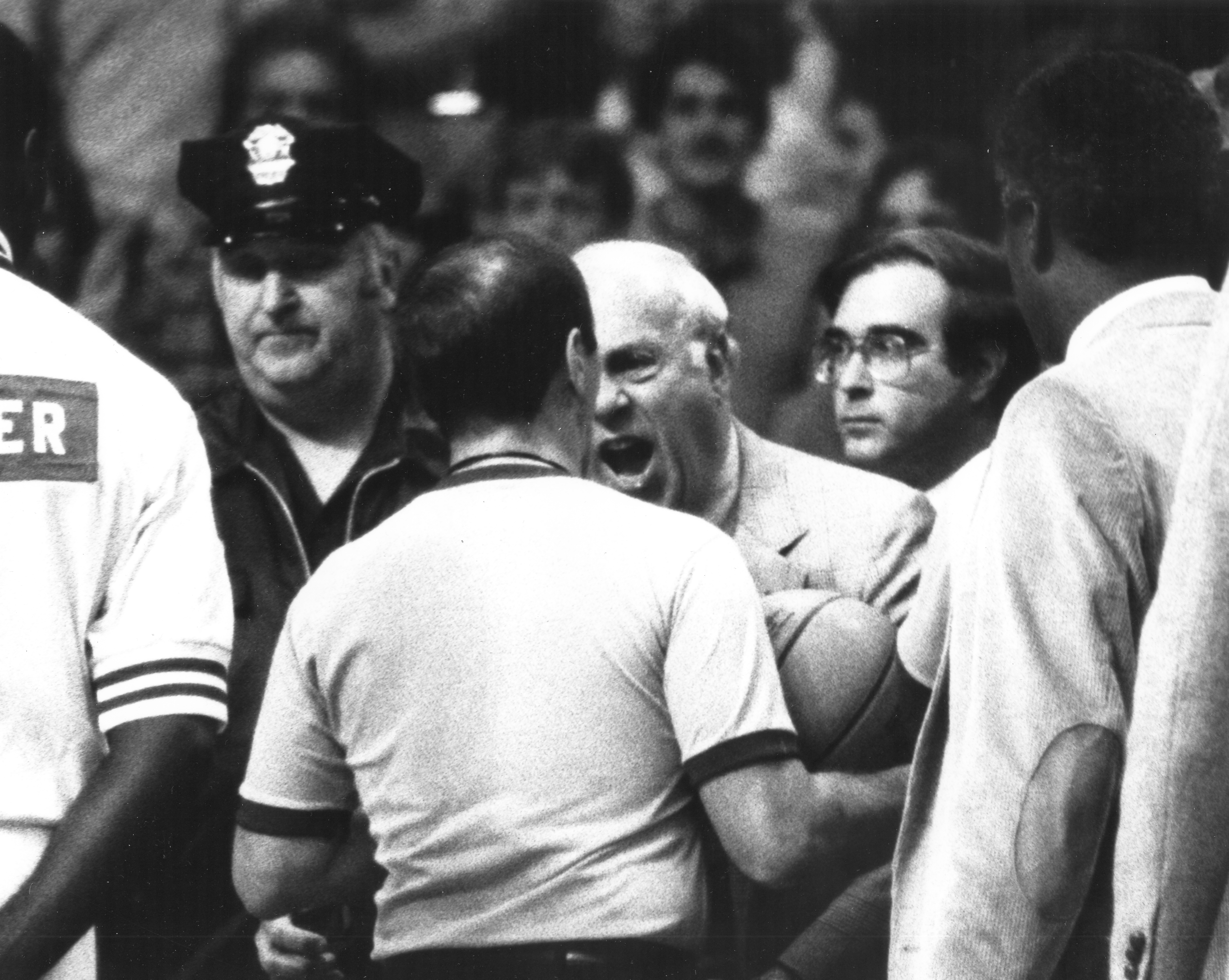 A furious Auerbach storms the court in 1983, with Volk visible over his shoulder.