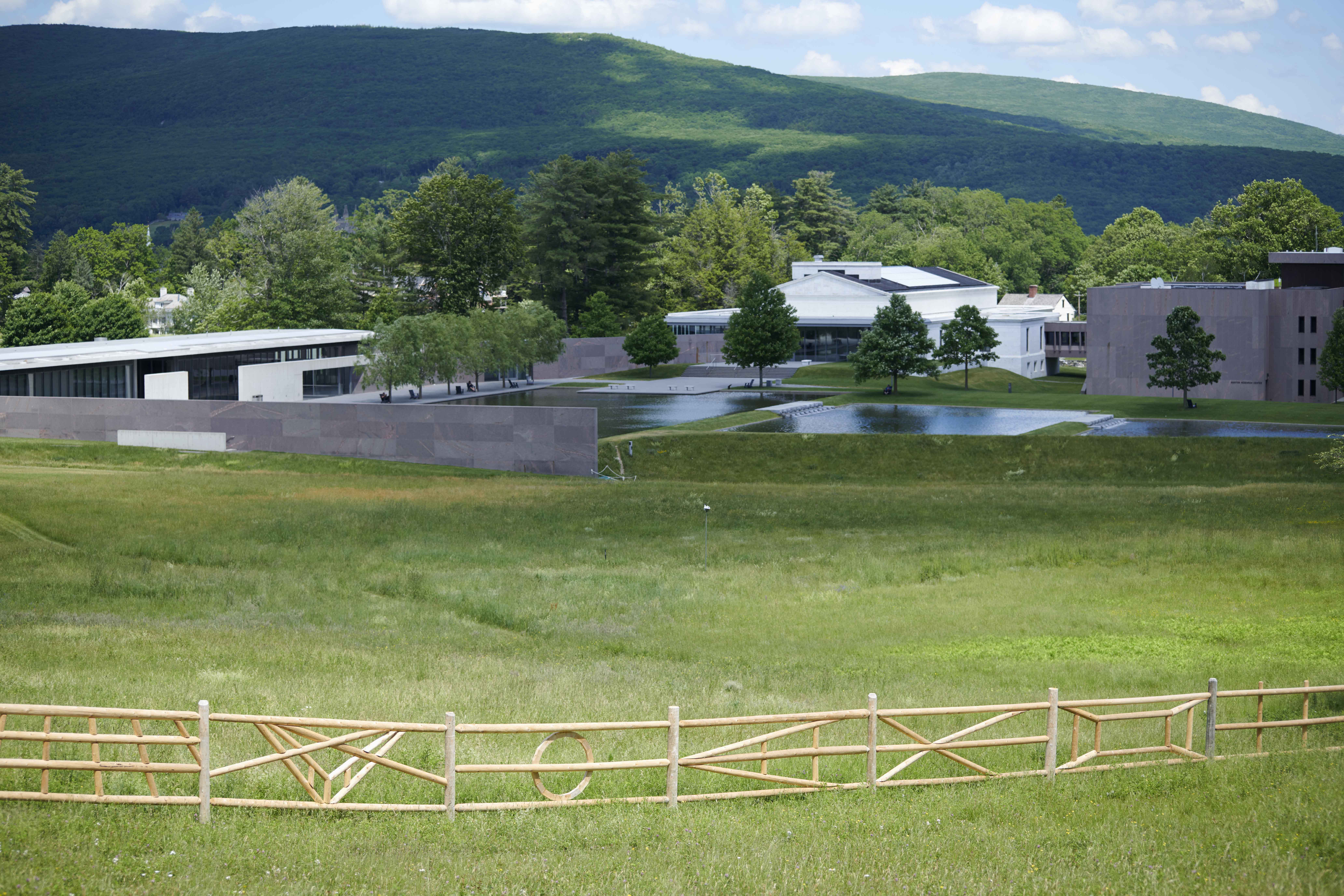 A view of the Clark Art Institute's grounds. Analia Saban’s “Teaching a Cow How to Draw” split-rail cedar fence is in the foreground.