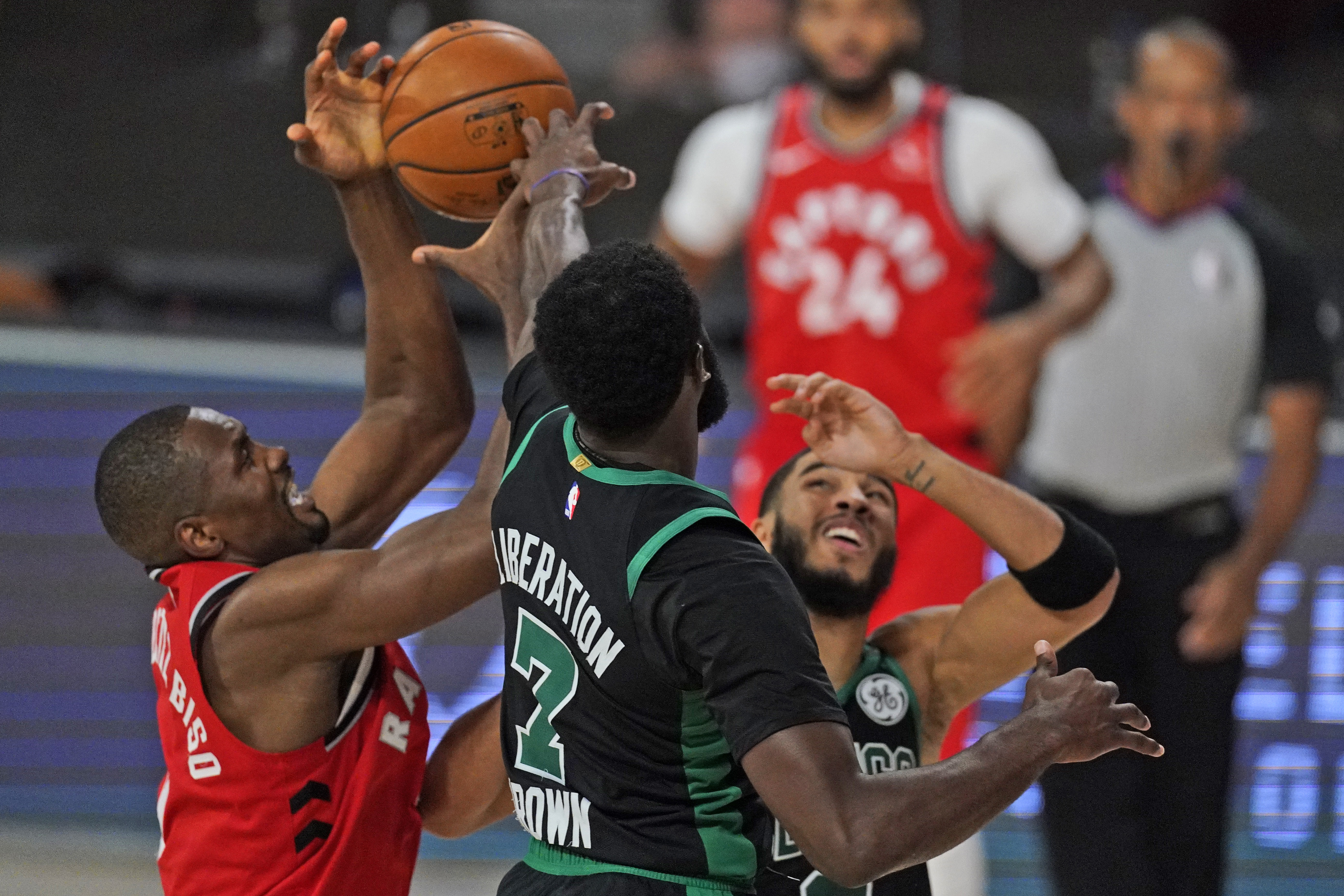 Toronto's Serge Ibaka and Jaylen Brown and Jayson Tatum battle for possession in the first half of Monday's game.