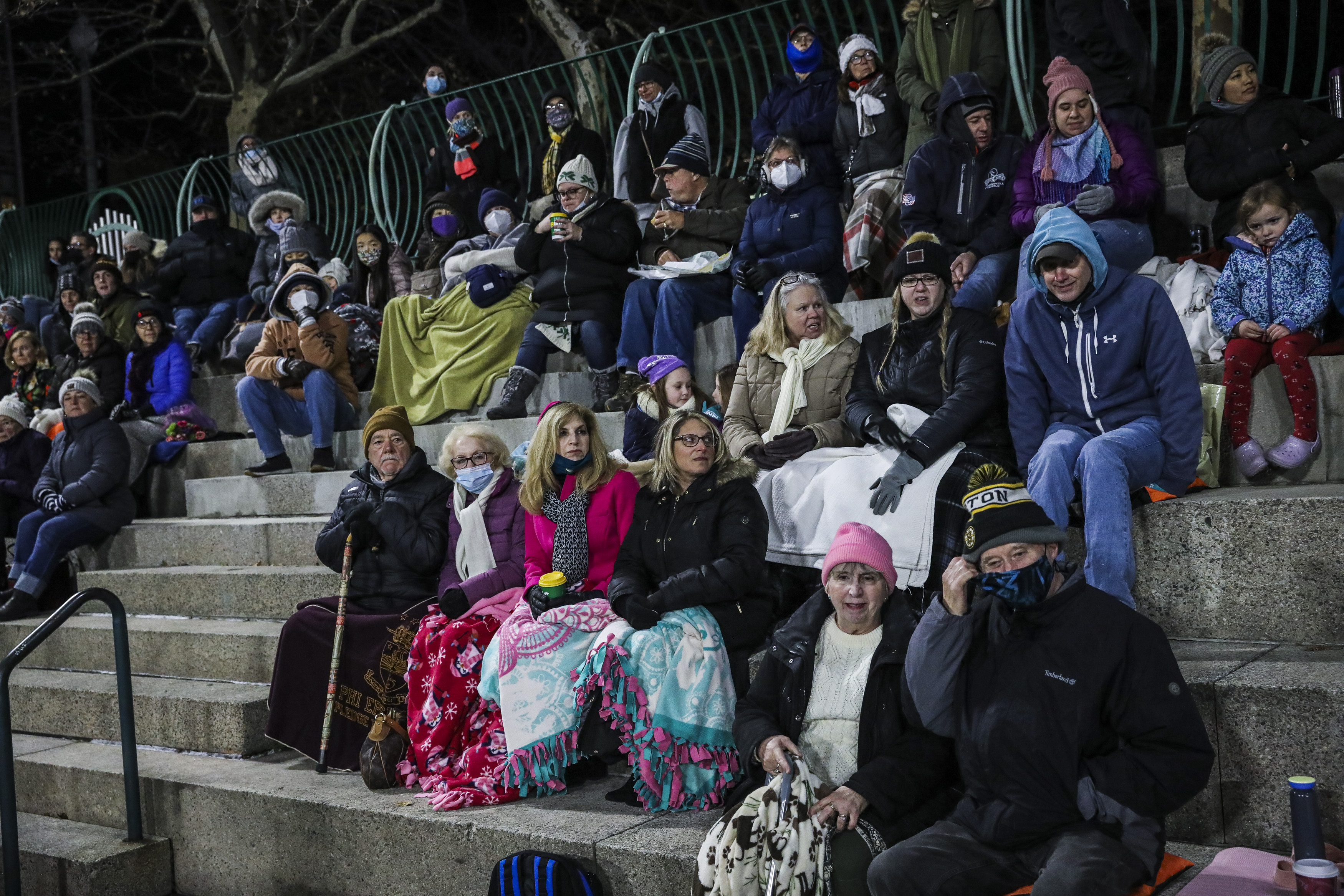 People wrap themselves in blankets as they sit around downtown BankNewport.