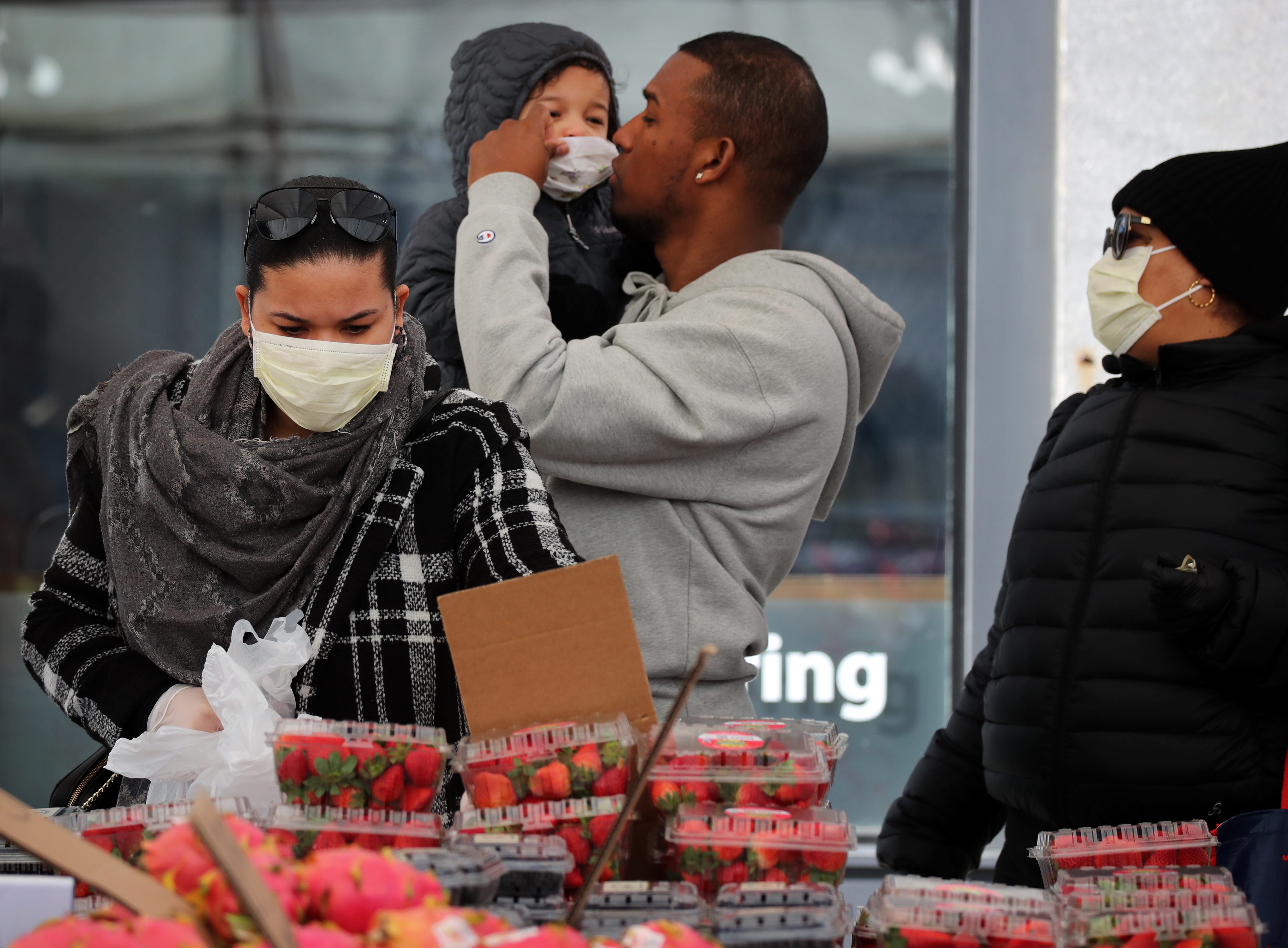 Alemao Menchaca carries his daughter, Zoe, 2, while his wife, Leticia (left), and mother, Vielka, shop for produce at Haymarket in March.