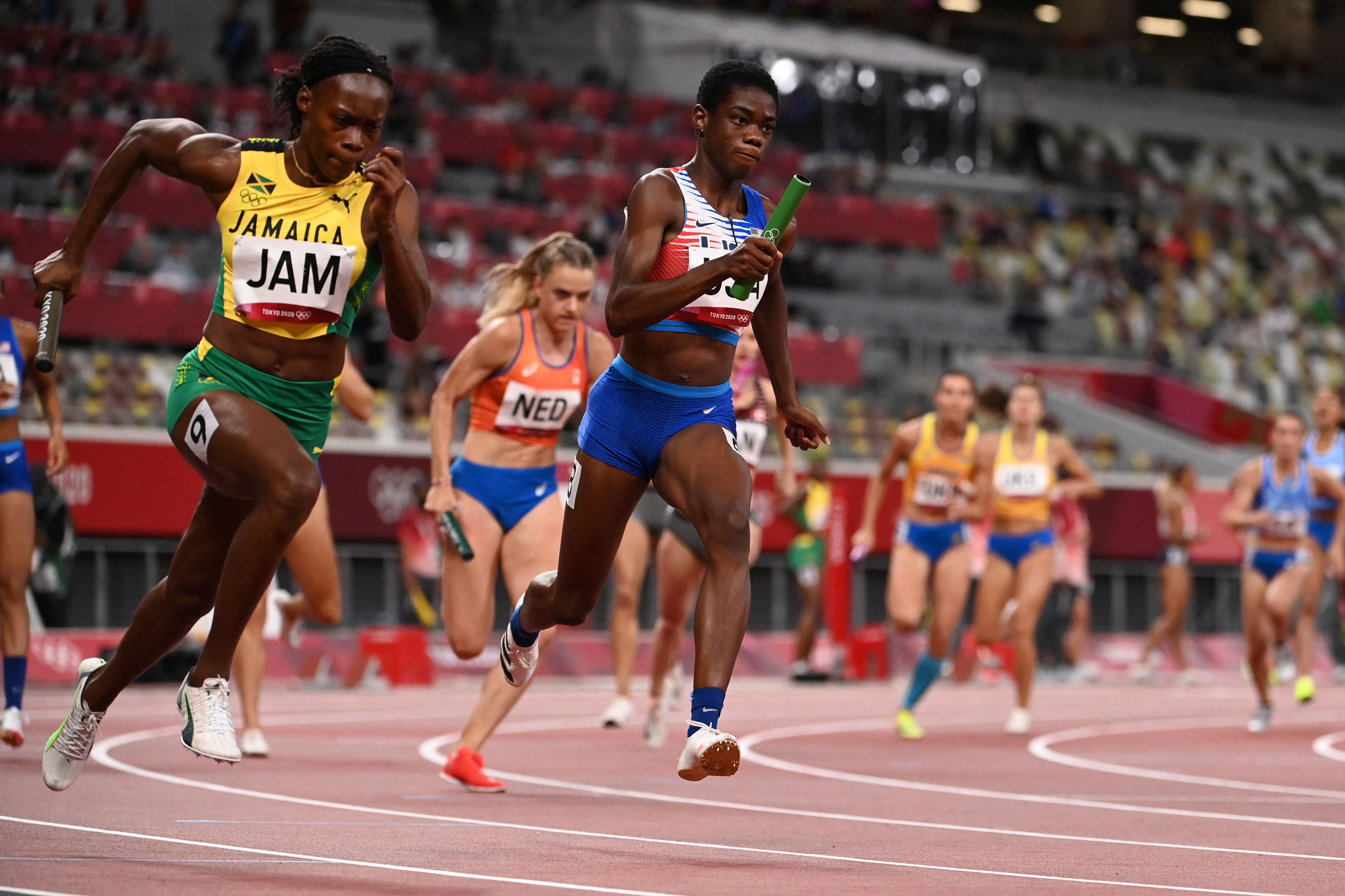 Wadeline Jonathas (center) races against Jamaica's Roneisha McGregor in the women's 4x100 meter heats.