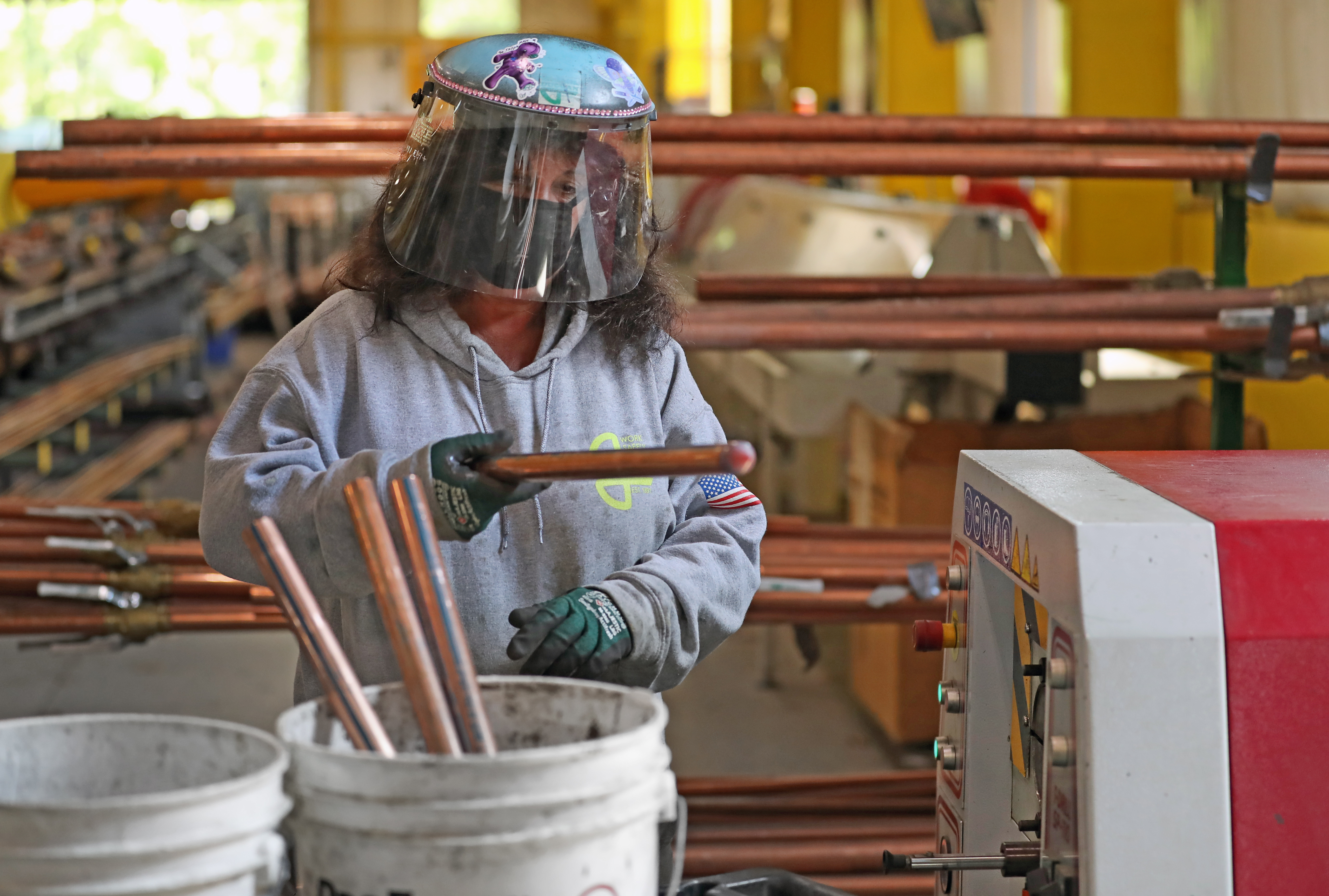 Kara Ruggeri wore a mask, gloves and shield while working on the factory floor at EM Duggan in Canton.