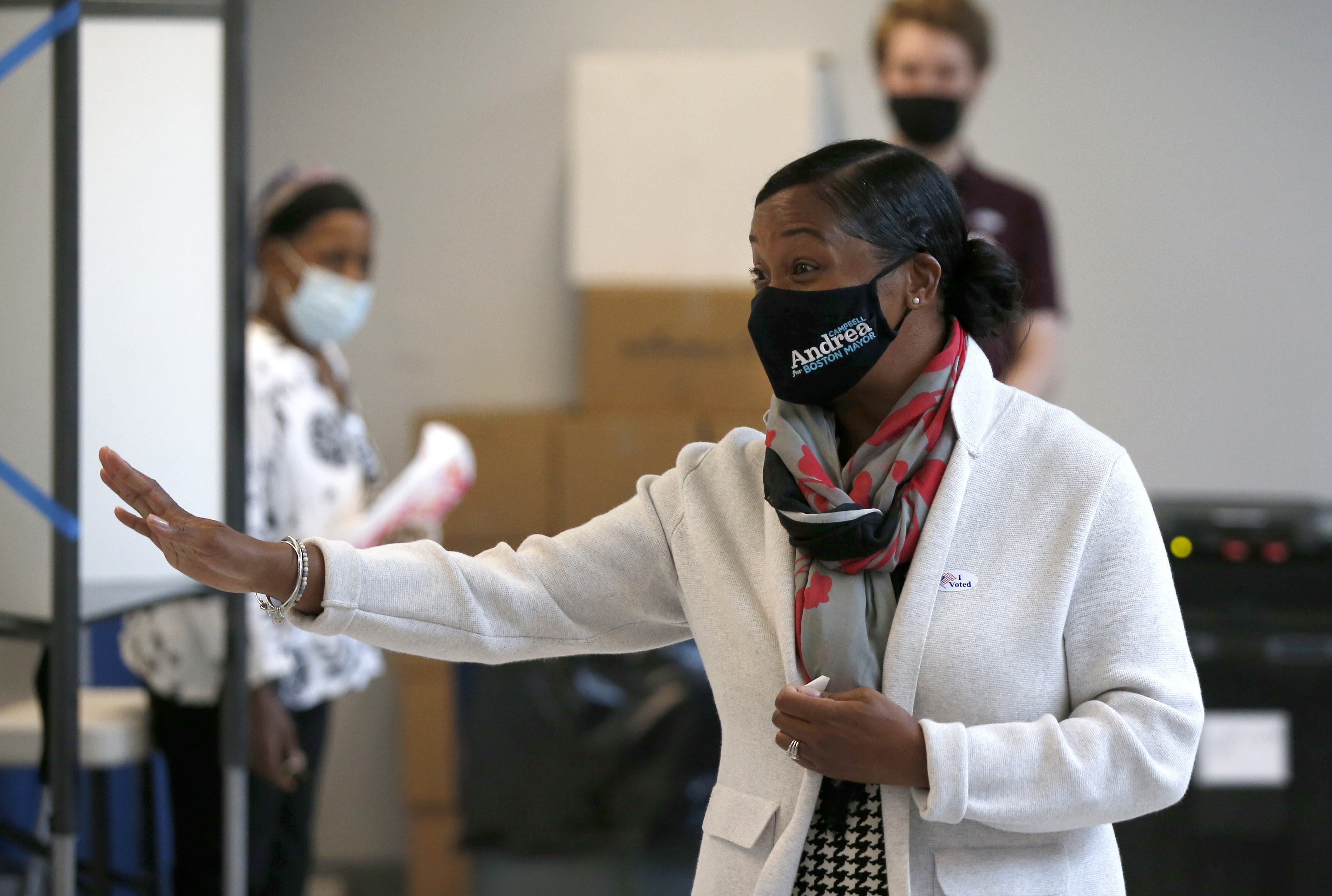 Andrea Campbell waves to poll workers after voting in Dorchester.