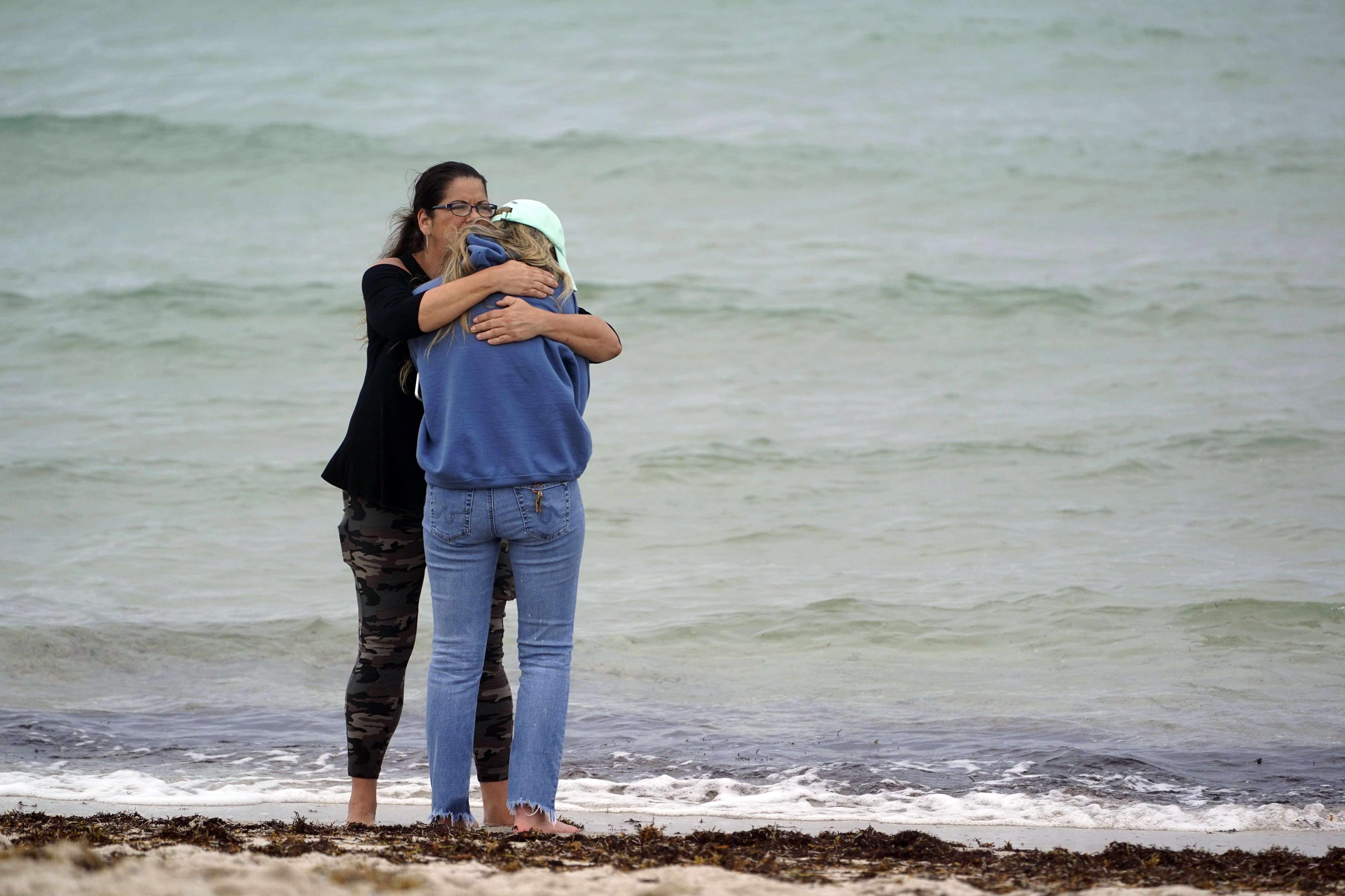 People consoled each other near the site of a partially collapsed building.