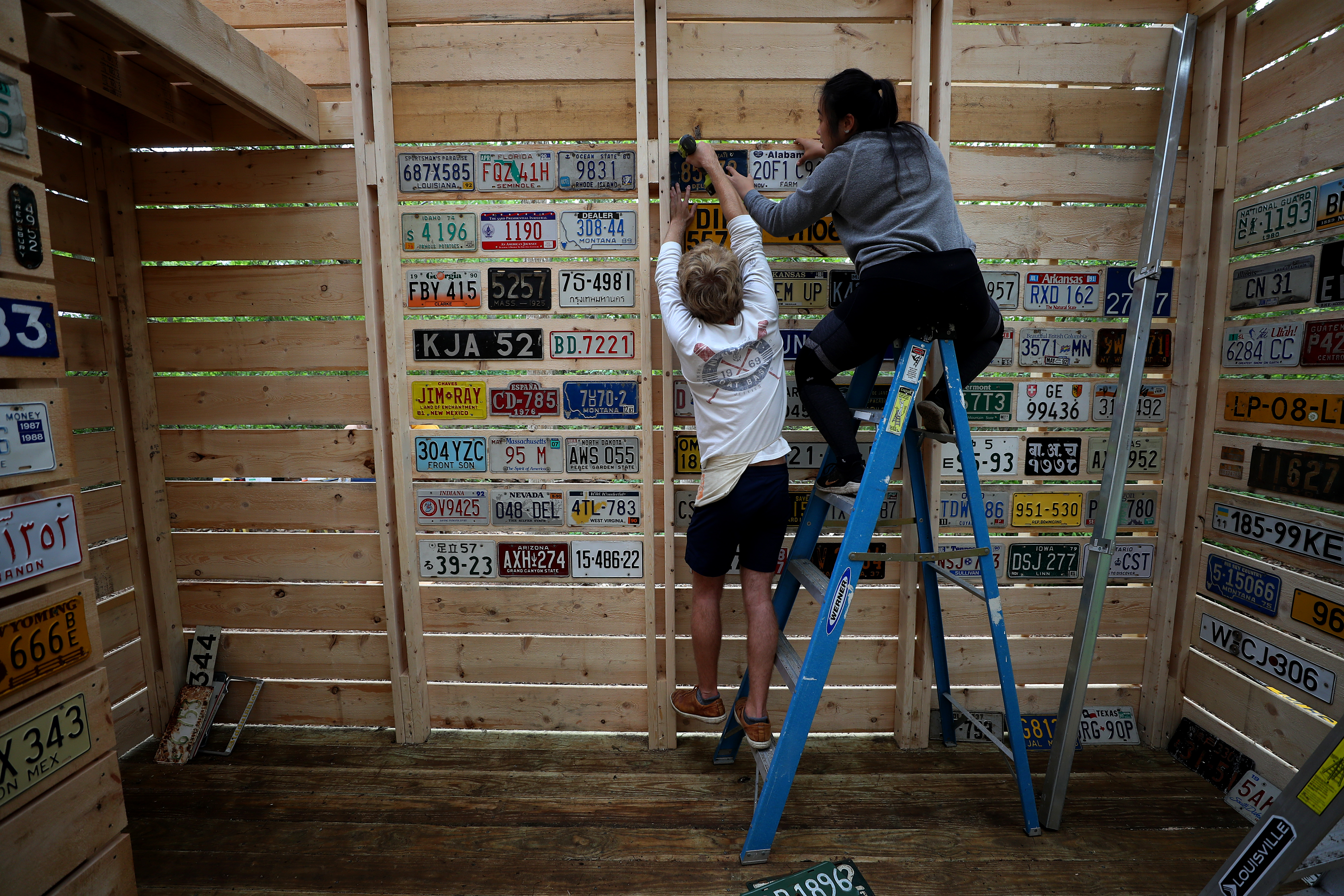 Architecture students Alex Rebhun, left, and Alice Fang hung license plates in the new cabin.