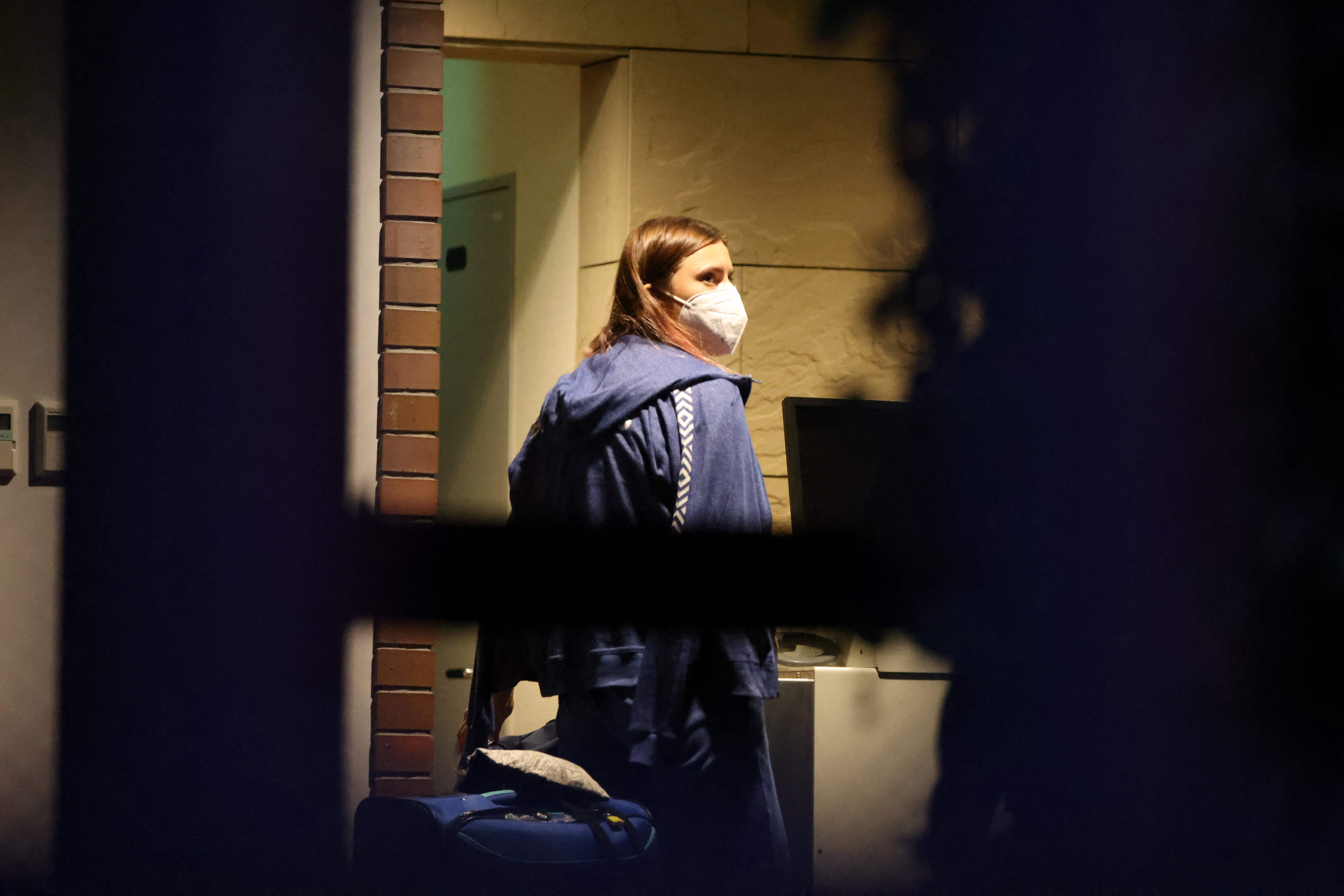 Belarus athlete Krystsina Tsimanouskaya walked with her luggage inside the Polish embassy in Tokyo on Monday.