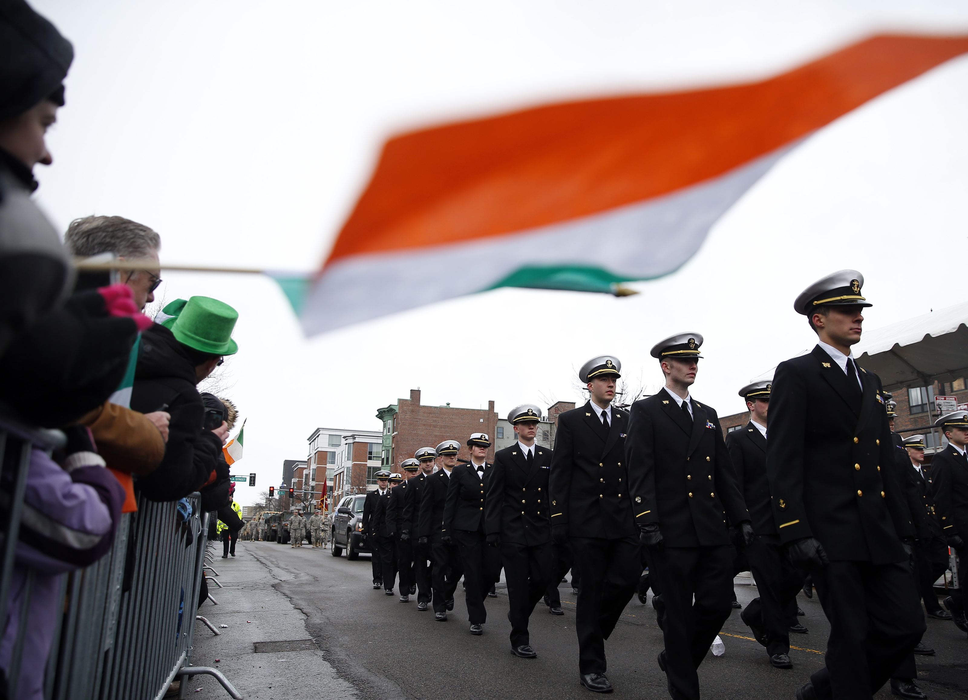 A person held an Irish flag as members of the Regimental Band and Honor Guard from Massachusetts Maritime Academy march during the 2015 parade.