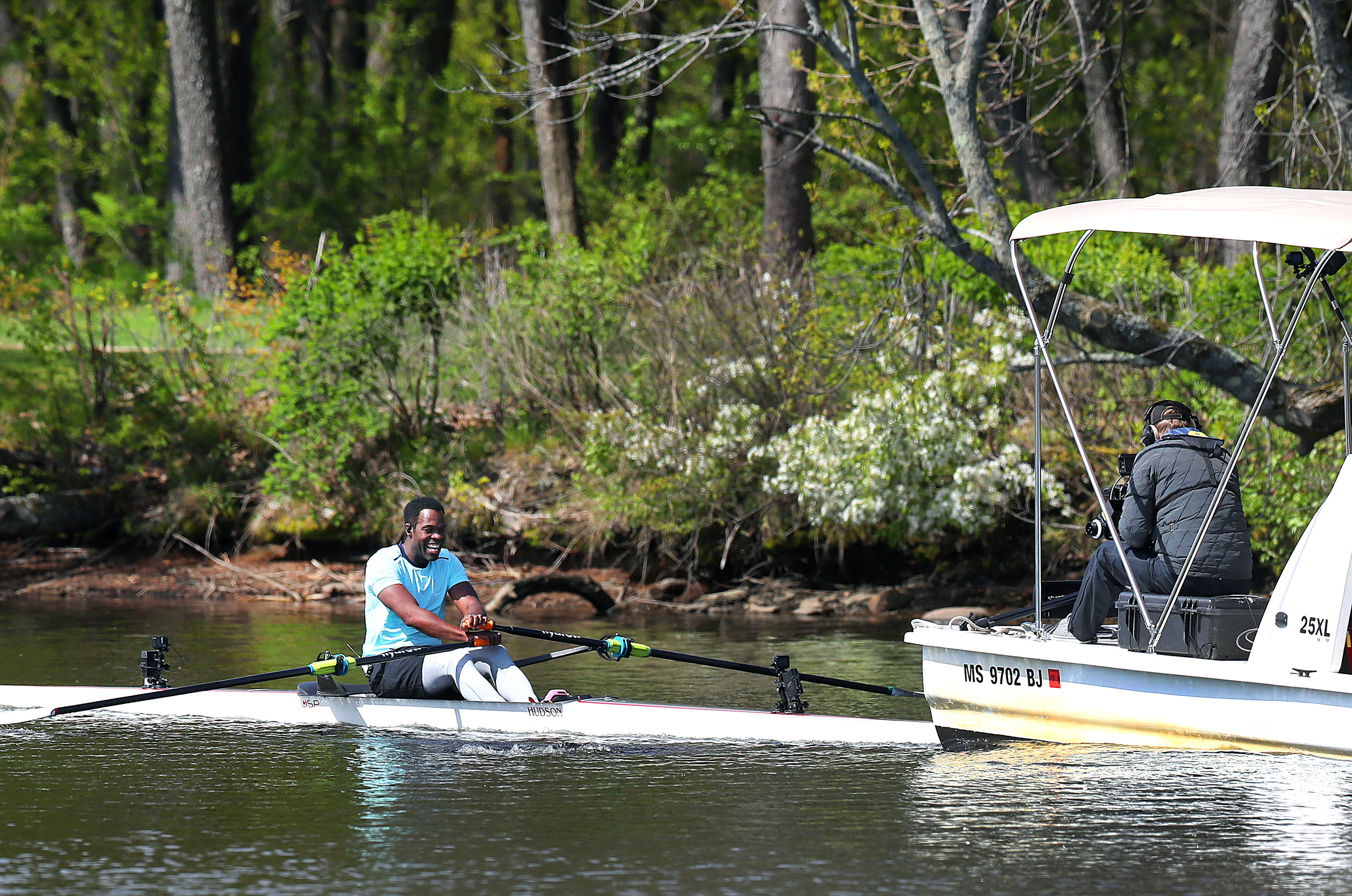 A camera streams video of Aquil Abdullah, a 2004 Olympian, as he rows along the Charles River.