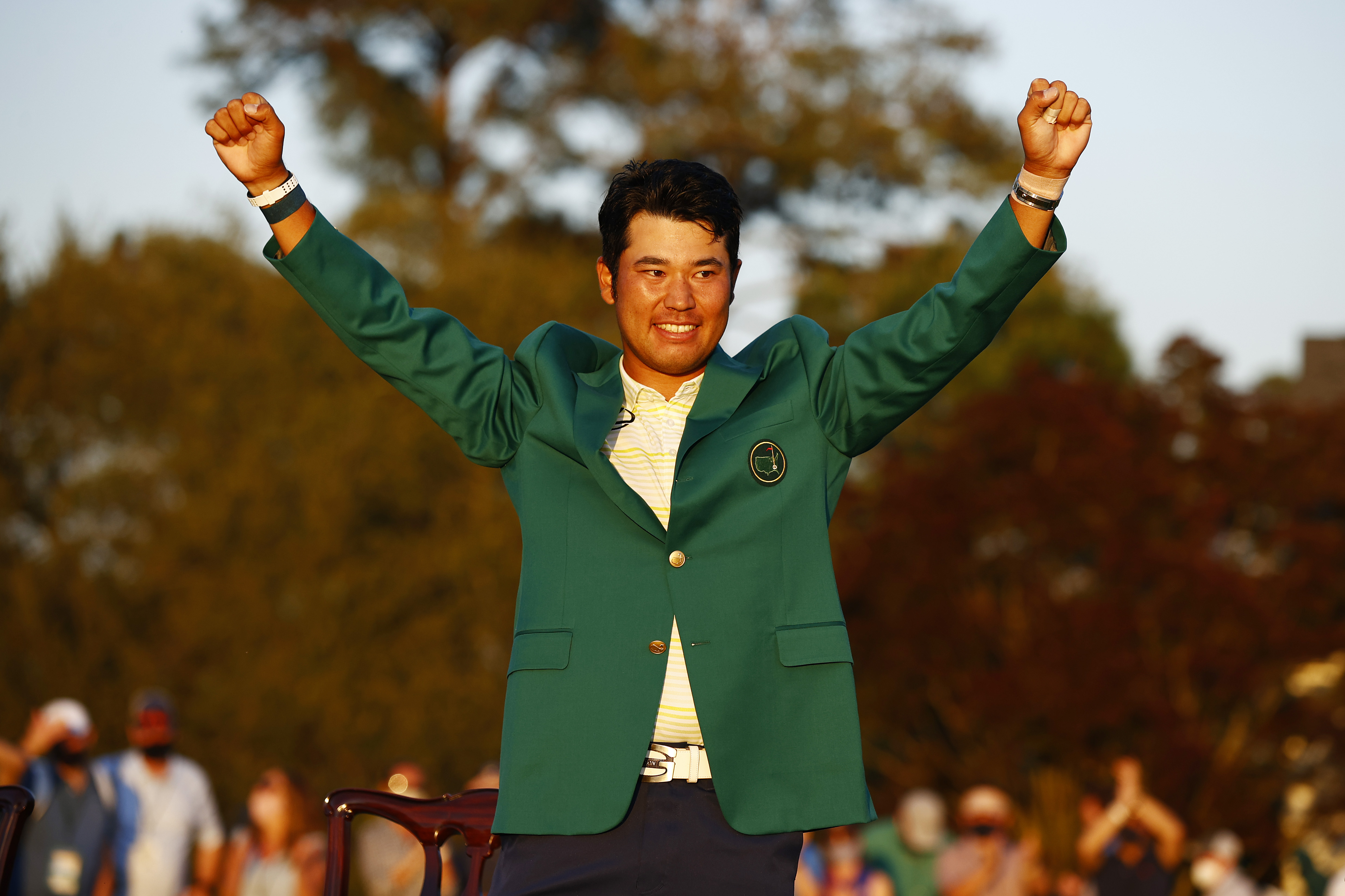 Hideki Matsuyama raises his fists while donning the green jacket after his Masters victory.