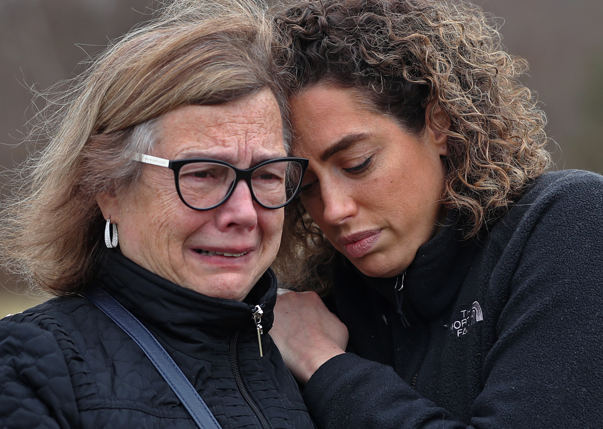 Grace Medeiros of Seekonk, Mass., is comforted by her daughter, Veronica Medeiros, as she talks about her son, Kayne, who died in March of COVID-19.
