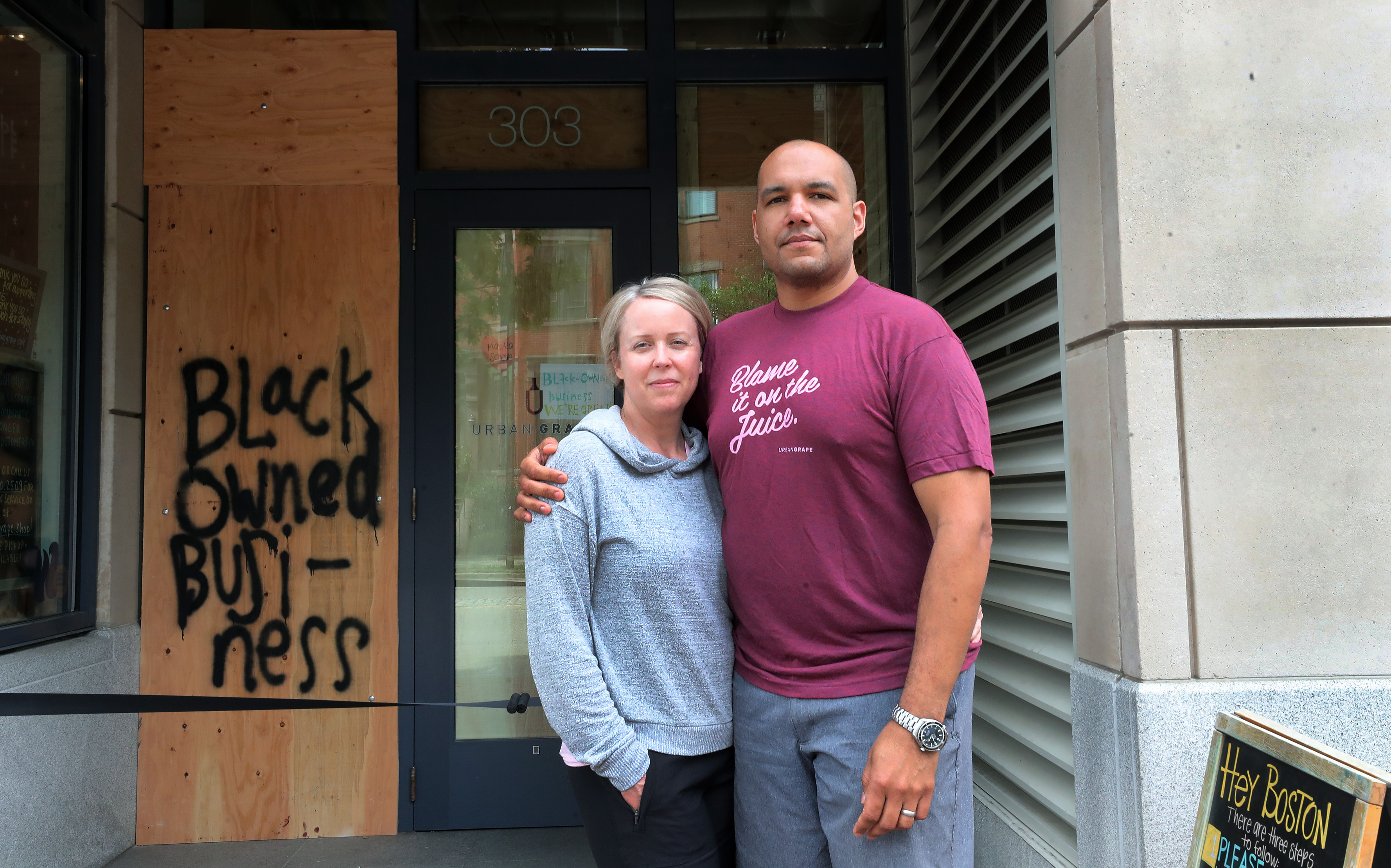 Hadley (left) and TJ (right) Douglas, the owners of the Urban Grape wine store on Columbus Avenue in the South End are pictured in front of their business.
