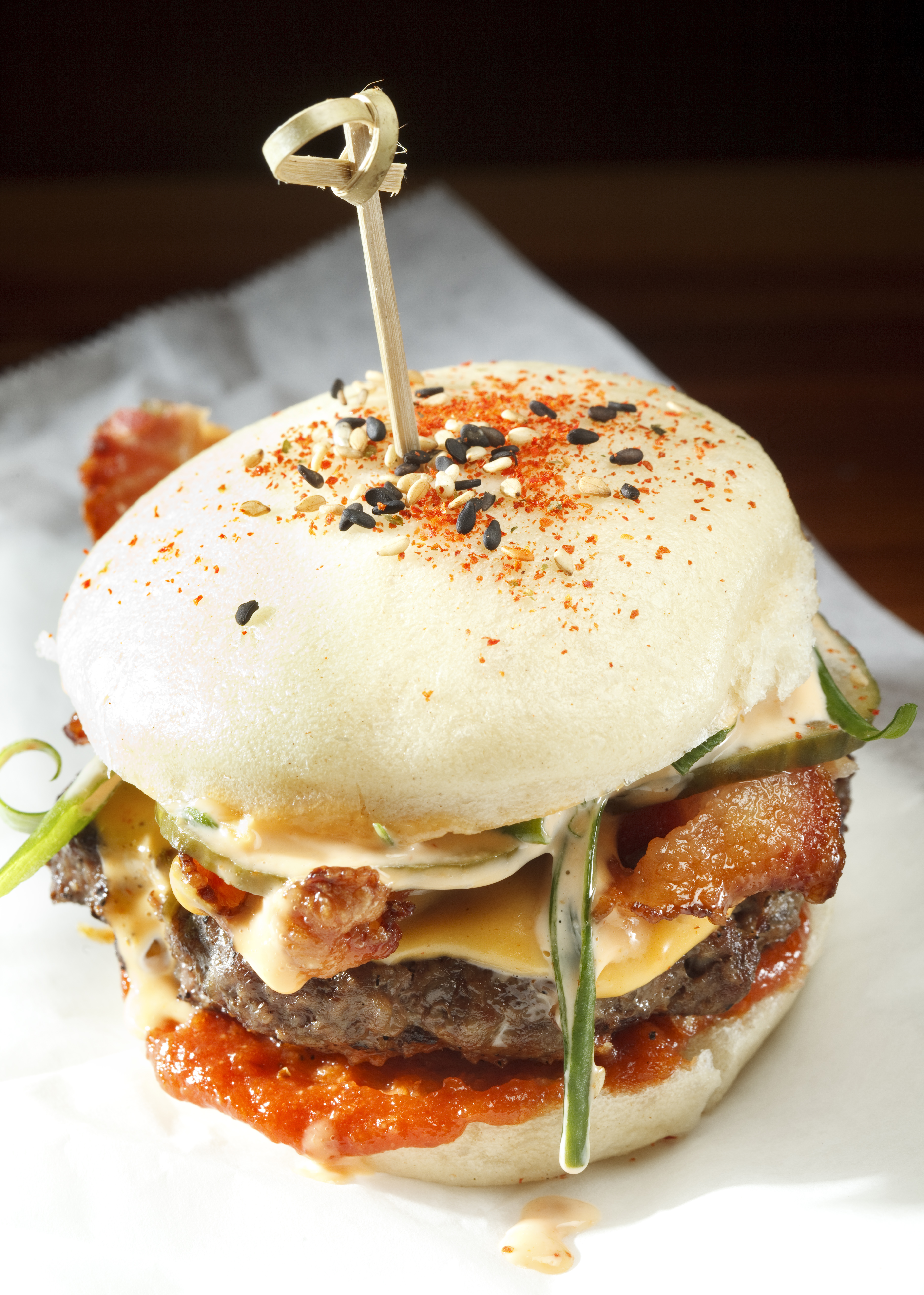 Shojo’s take on the burger, “The Shojonator,” is a 4-ounce patty on a steamed bao, with bacon and “kimcheese.”