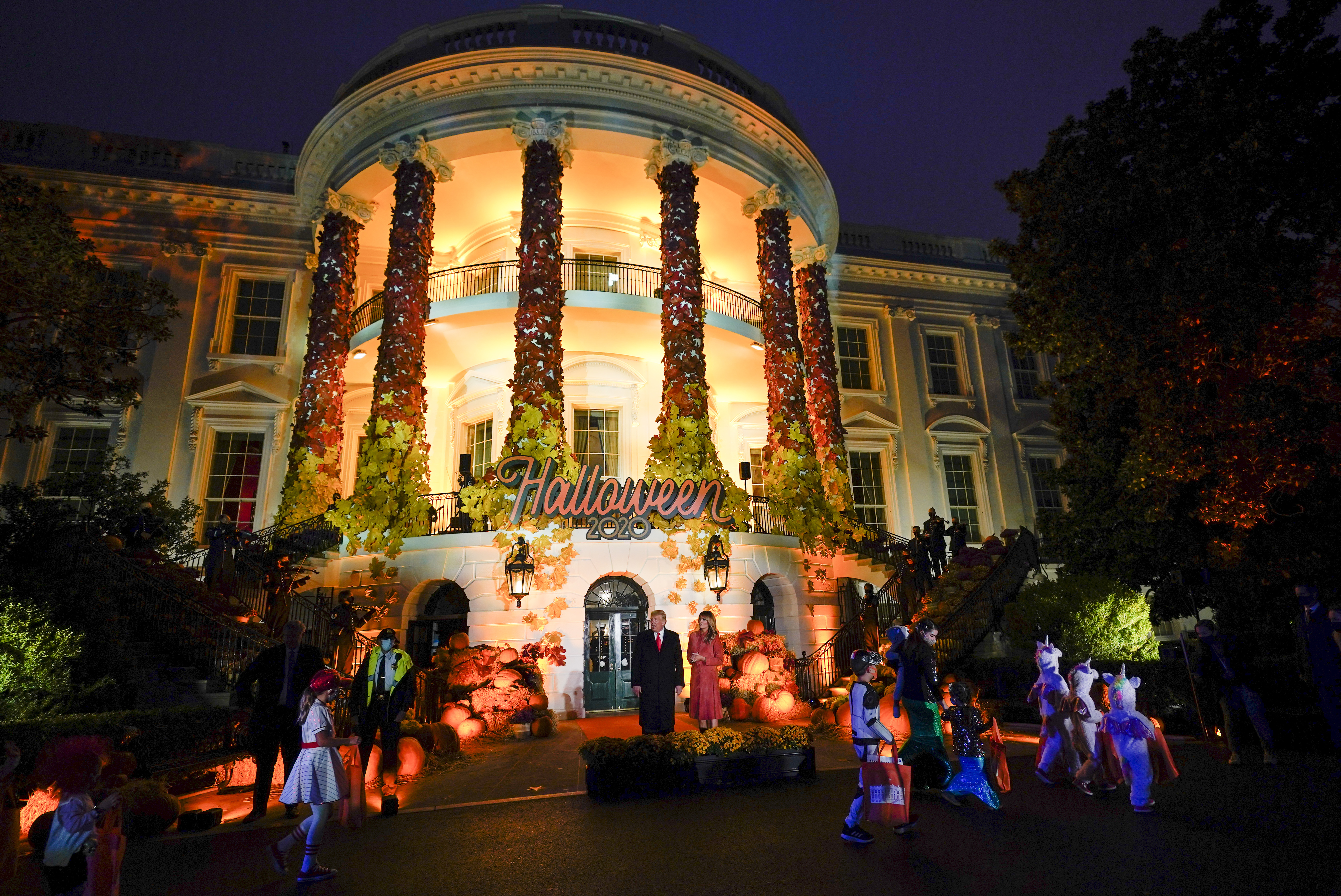 President Donald Trump and first lady Melania Trump greet trick-or-treaters on the South Lawn during a Halloween celebration at the White House, Sunday, Oct. 25, 2020 in Washington.