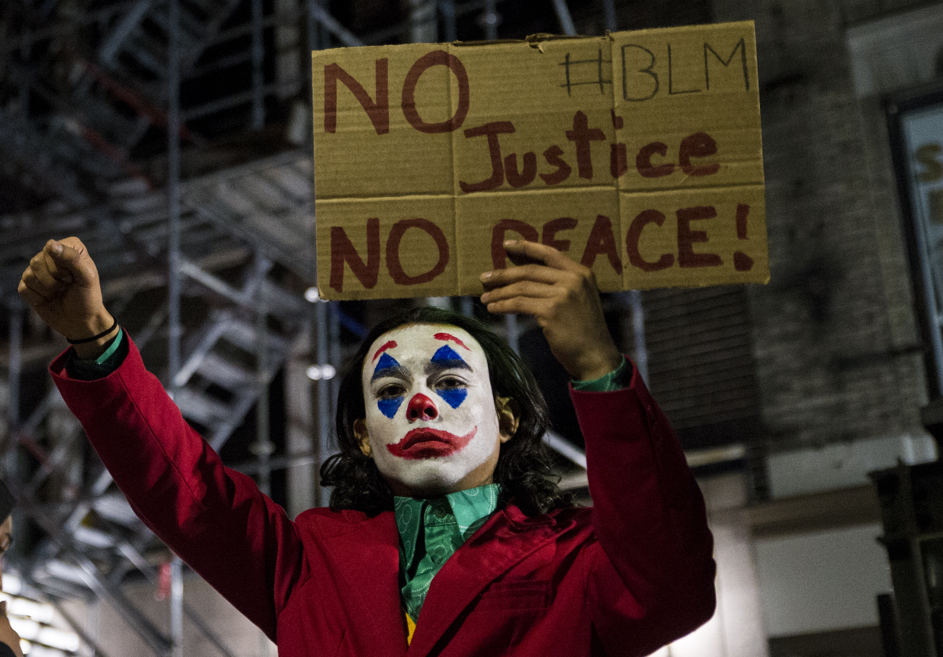 A protester dressed as the Joker stood on a construction barrier on Tremont Street.