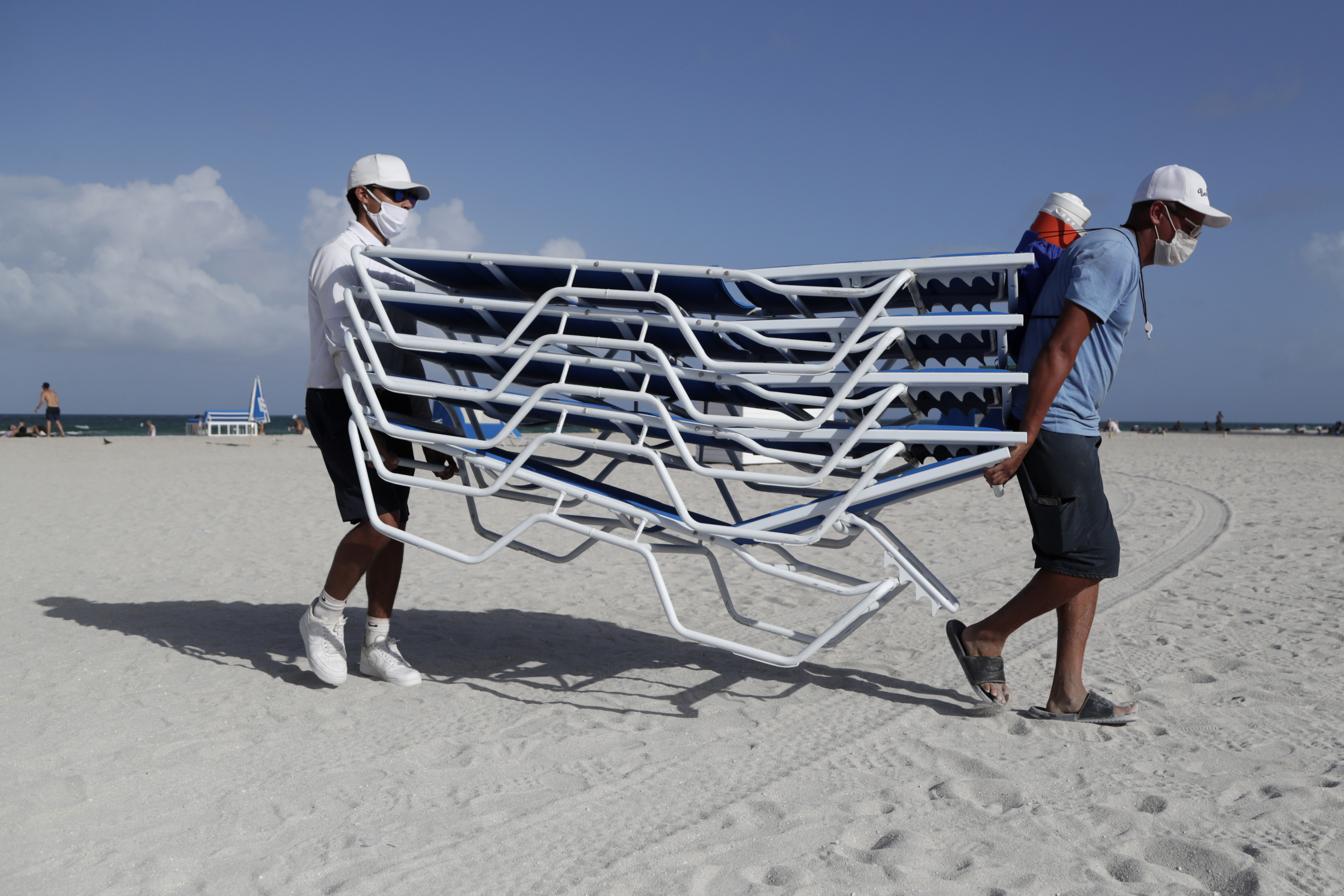 Workers removed chairs from the beach in preparation for Hurricane Isaias, on Friday in Miami Beach, Fla.