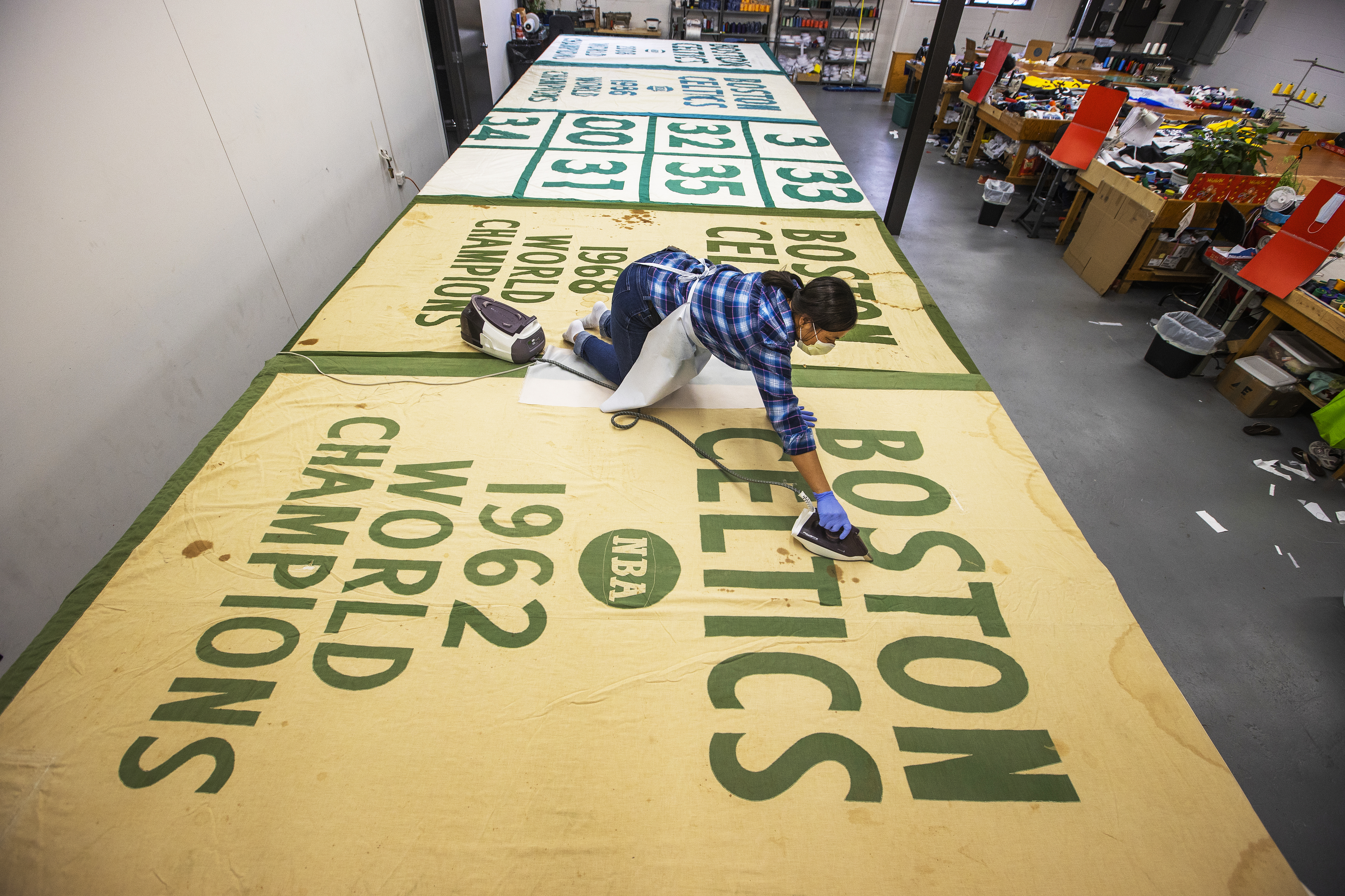 New England flag and banner seamstress Terry Wu re-passes the 1962 championship banner in weathered cotton.