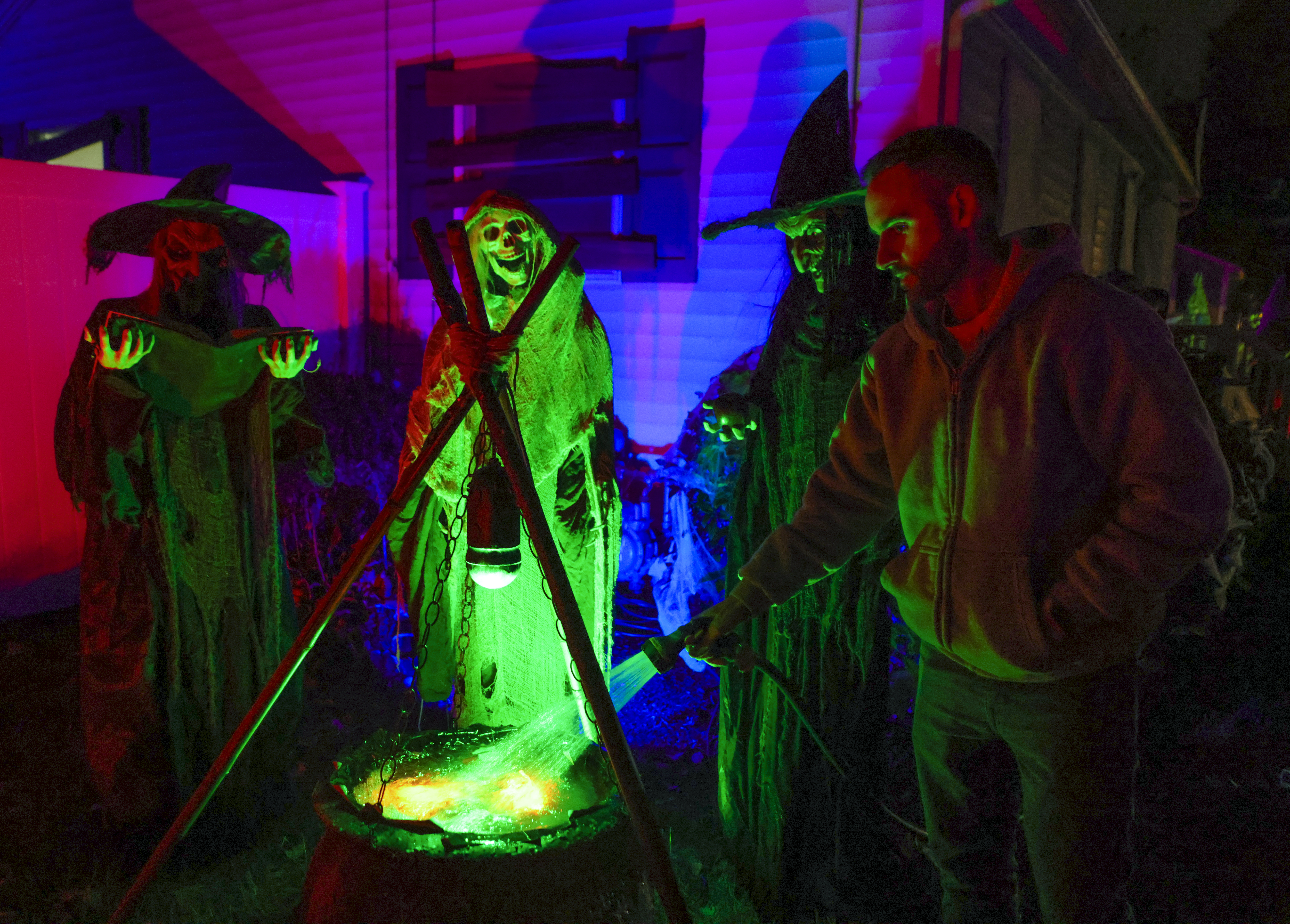 Steve Sardella fills up a Halloween cauldron in front of his home.