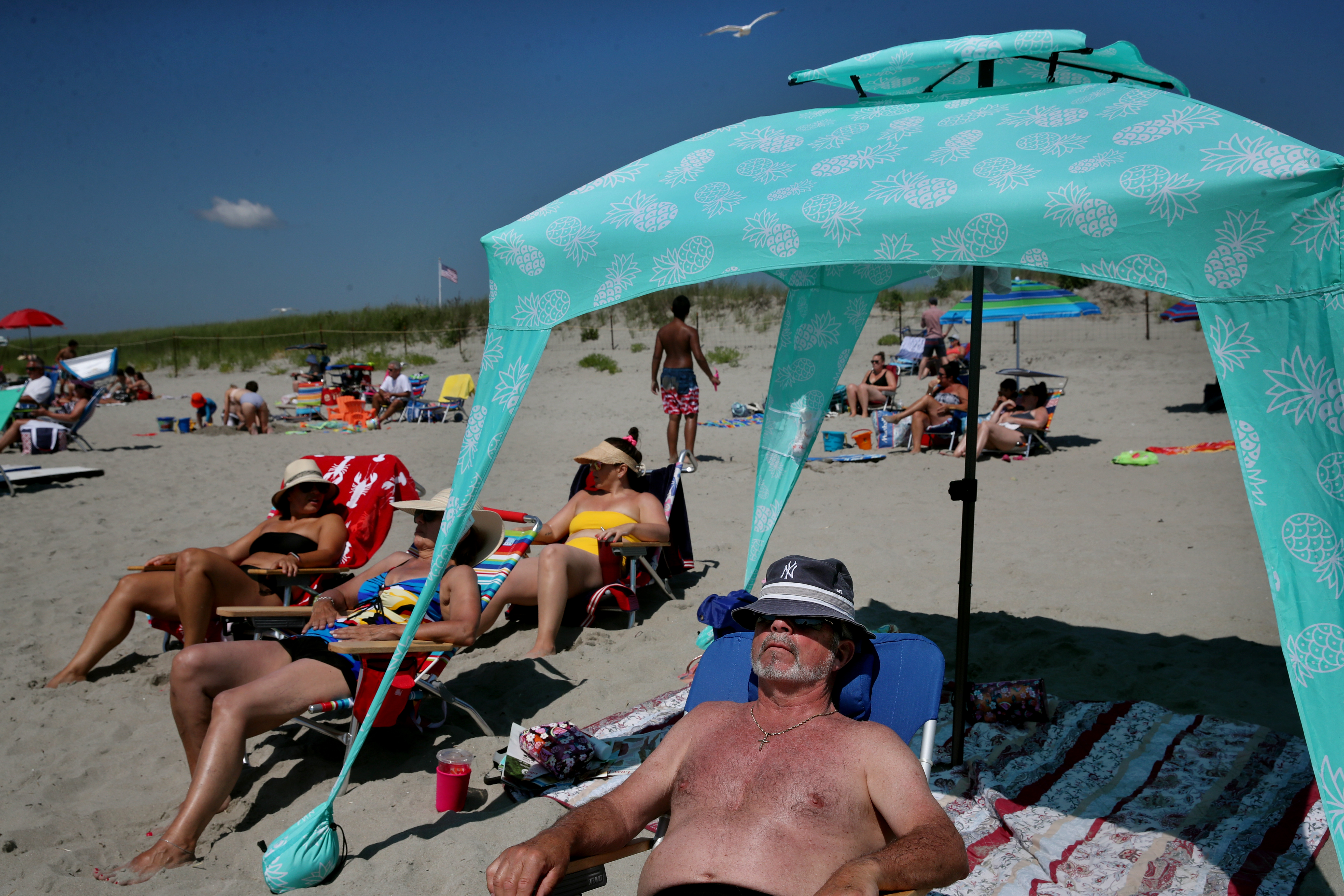 People bathe in the sun at Good Harbor Beach in Gloucester.