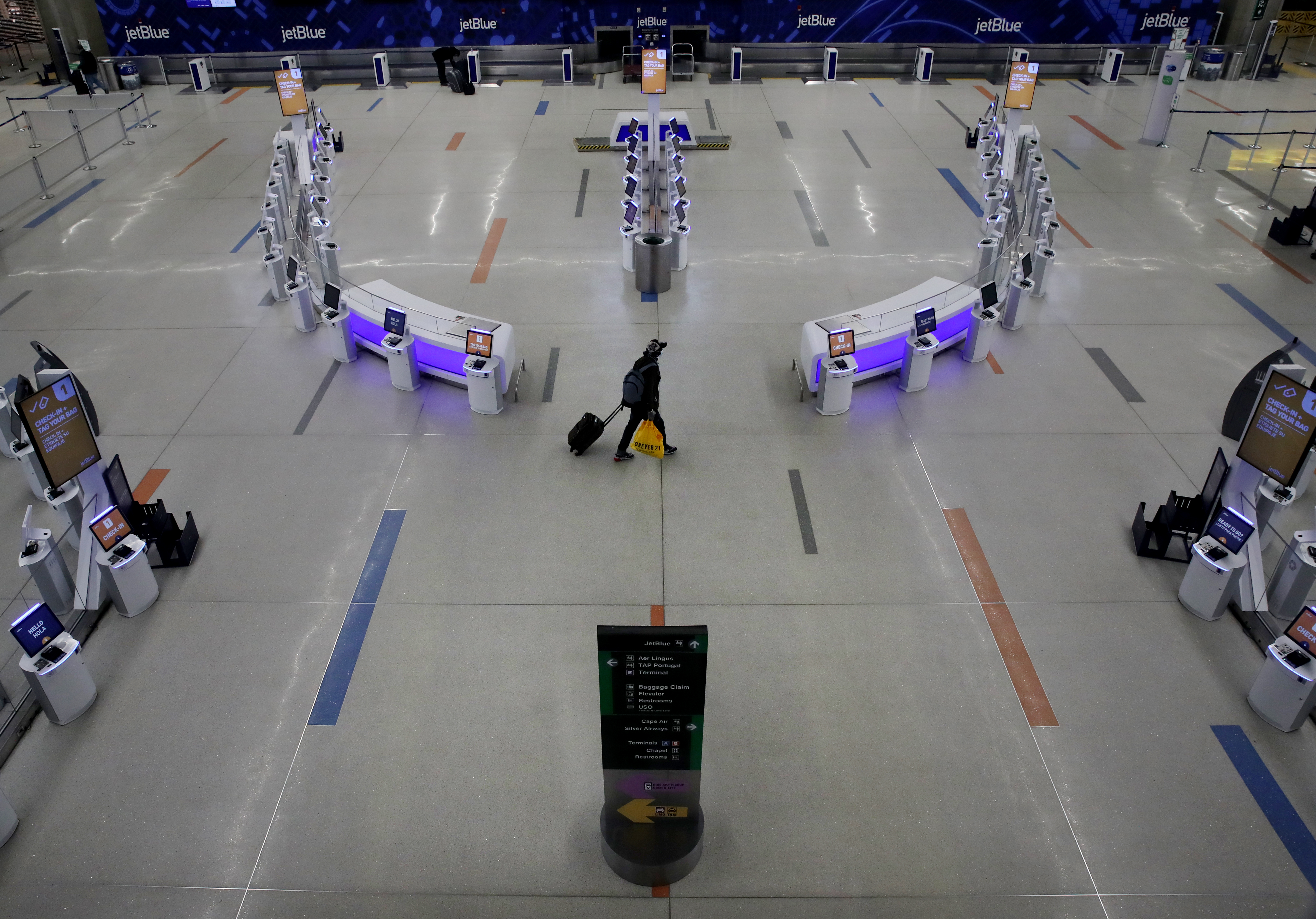 Boston, MA - 4/2/2020: Travelers pass through the B concourse at Boston Logan International Airport in Boston, MA on April 02, 2020. (Craig F. Walker/Globe Staff)