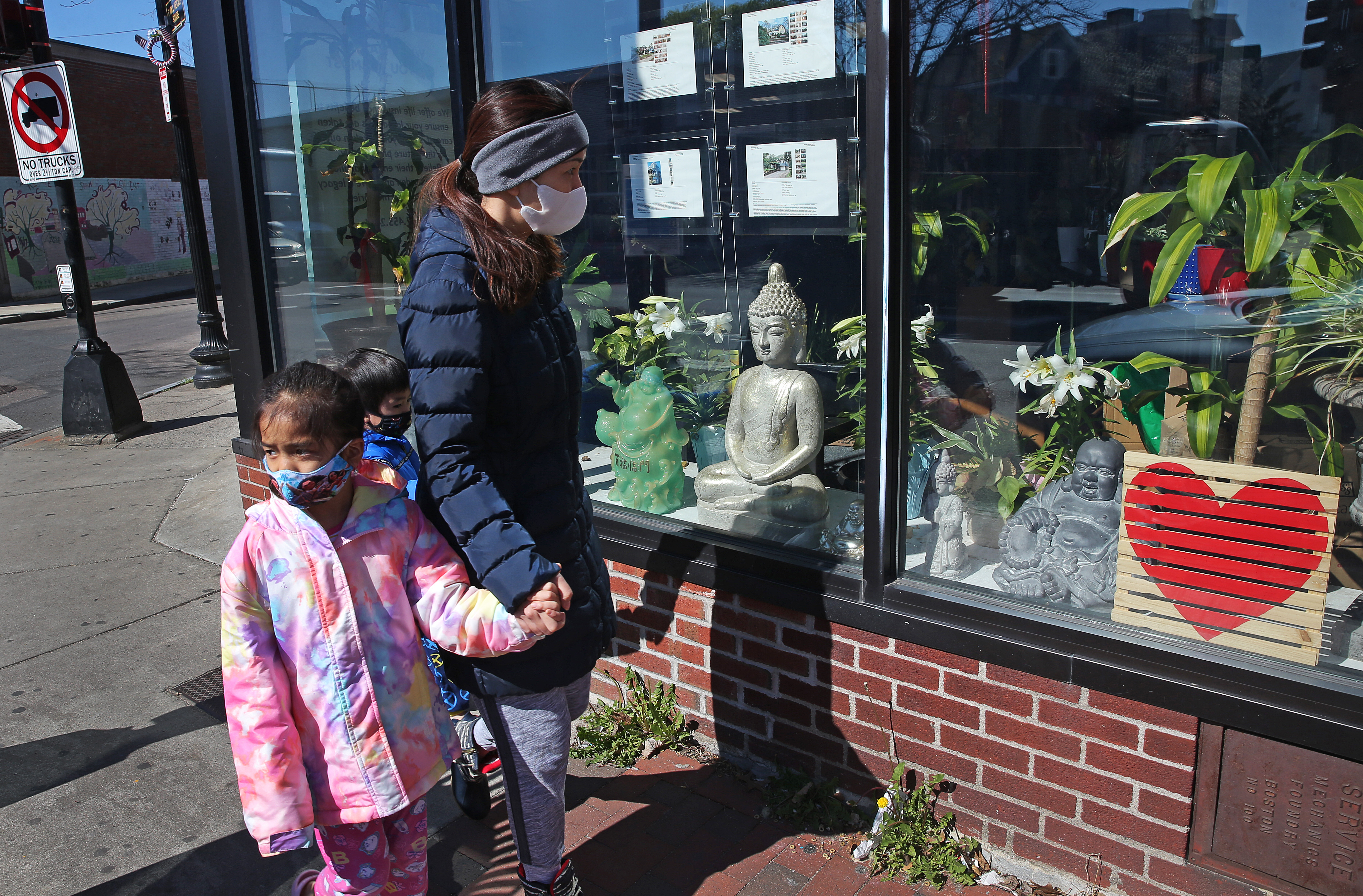 A family walked past a storefront on Dorchester Avenue.