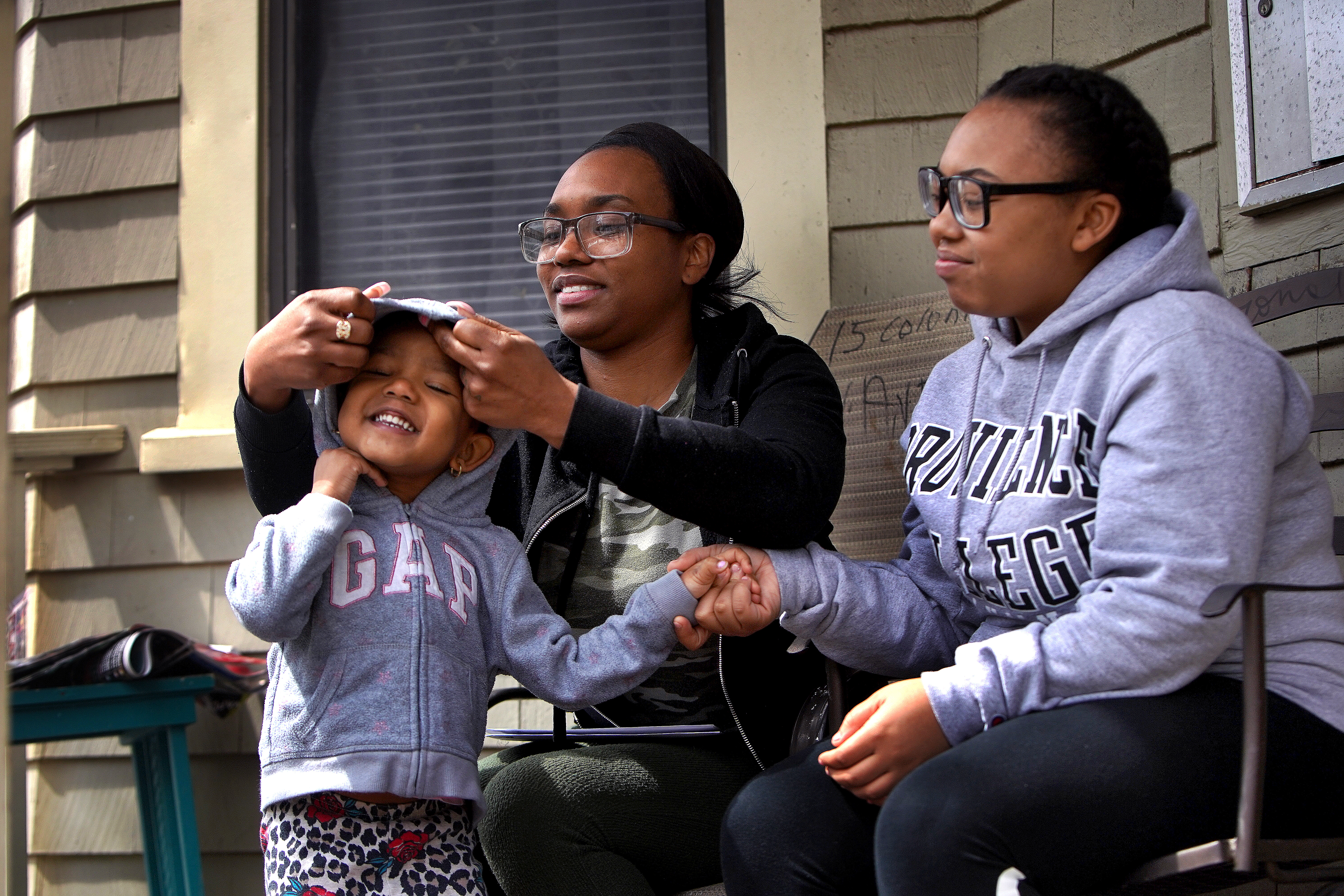 Jaliyah Bacchus (right), an honor student, is glad to help out her mother, Trisha Anderson, and spend more time with her younger sister, Jayda, whom she affectionately describes as "my littlest best friend."