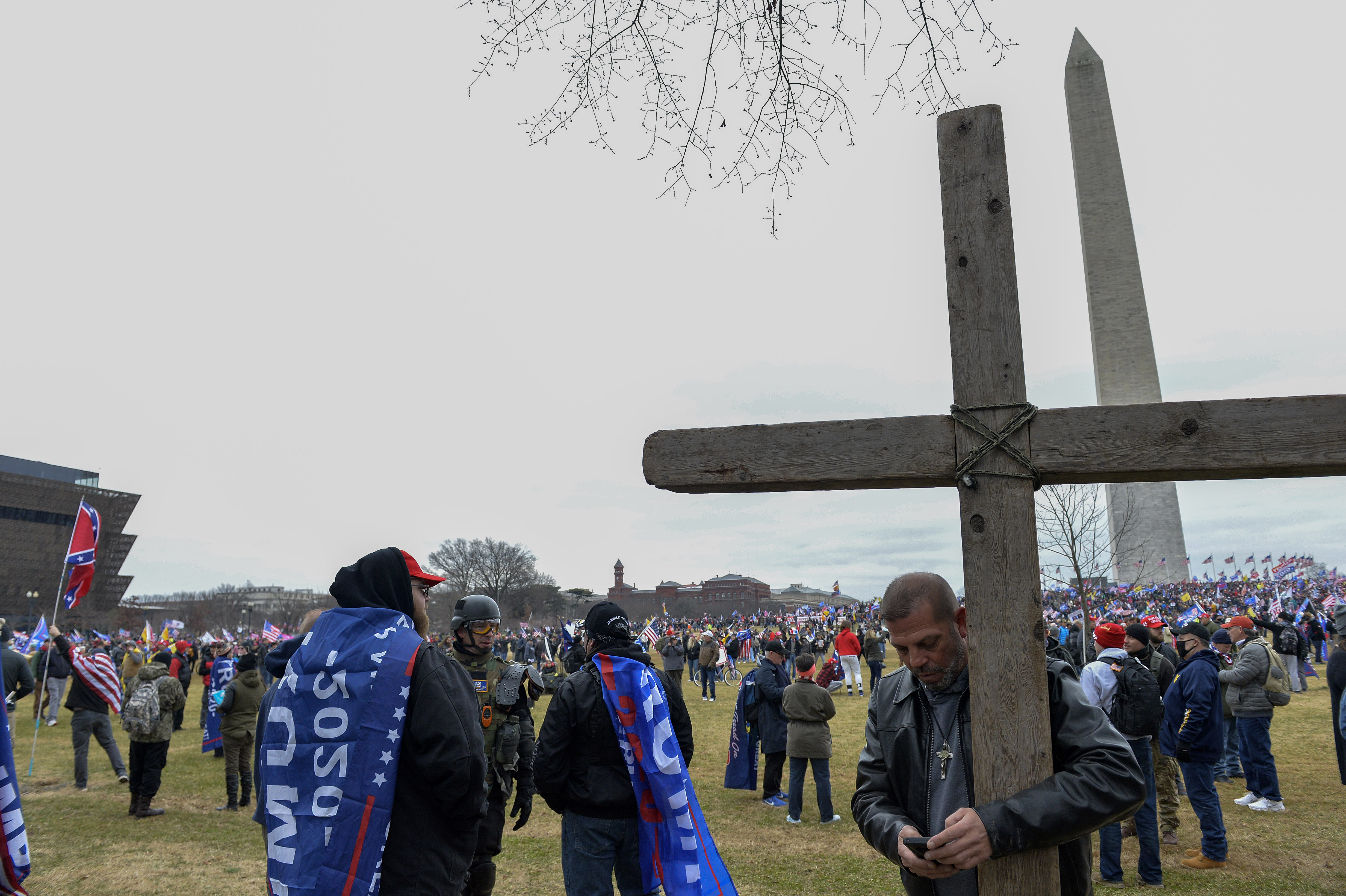 A man held a large wooden cross at the Trump rally before the Capitol was breached.