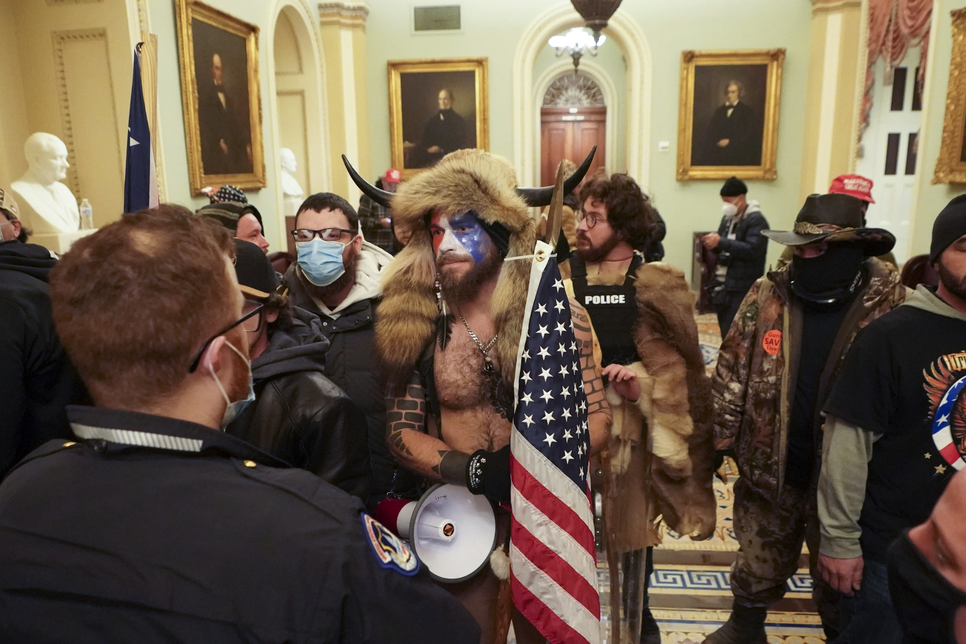 Jacob Anthony Chansley (center), with other supporters of President Trump who swarmed the US Capitol, confronted Capitol Police officers in the building on Jan. 6.