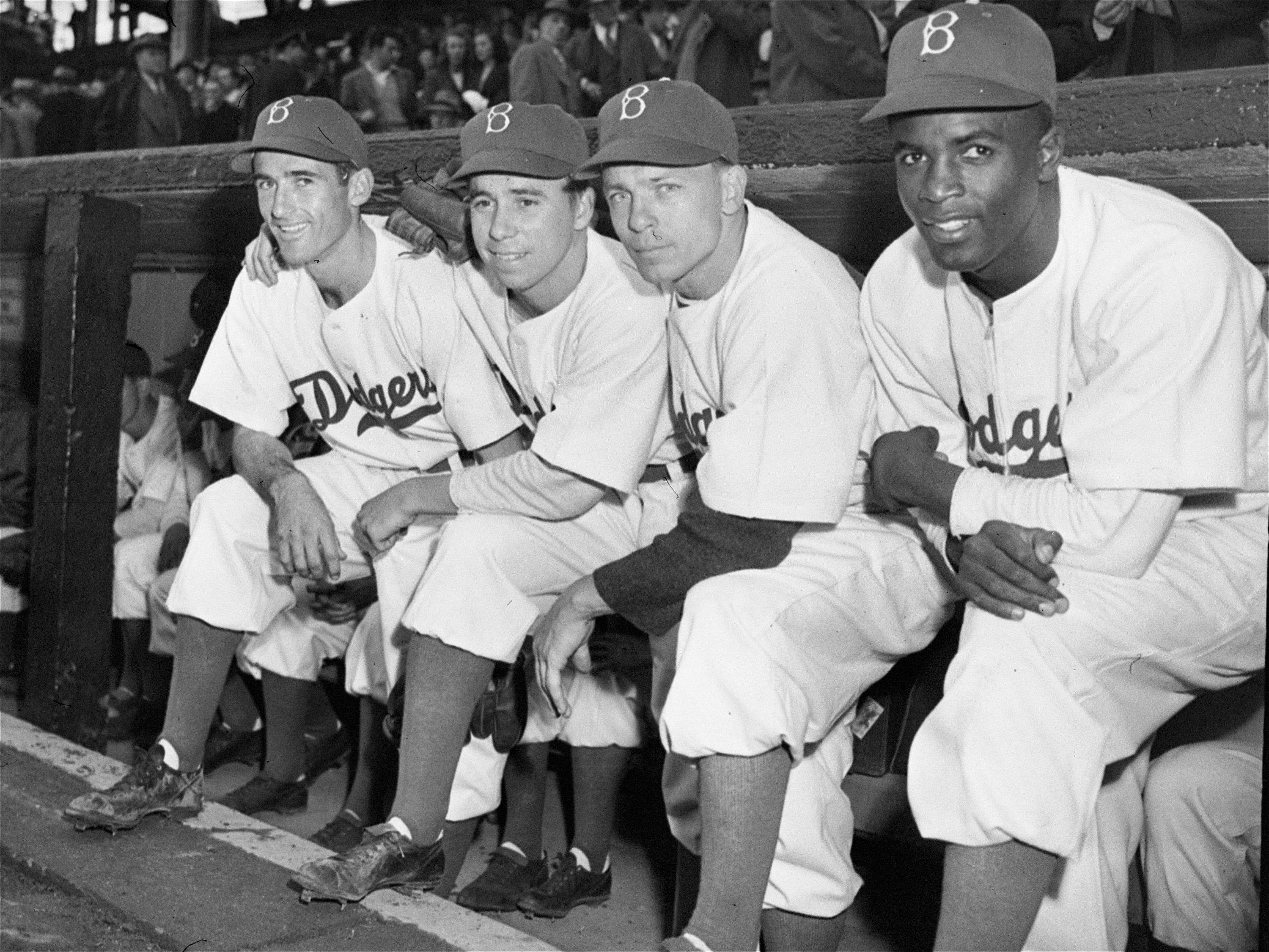 April 15, 1947: Jackie Robinson joins teammates John Jorgensen (left), Pee Wee Reese, and Ed Stanky on the dugout steps before making his debut and breaking MLB's color barrier.
