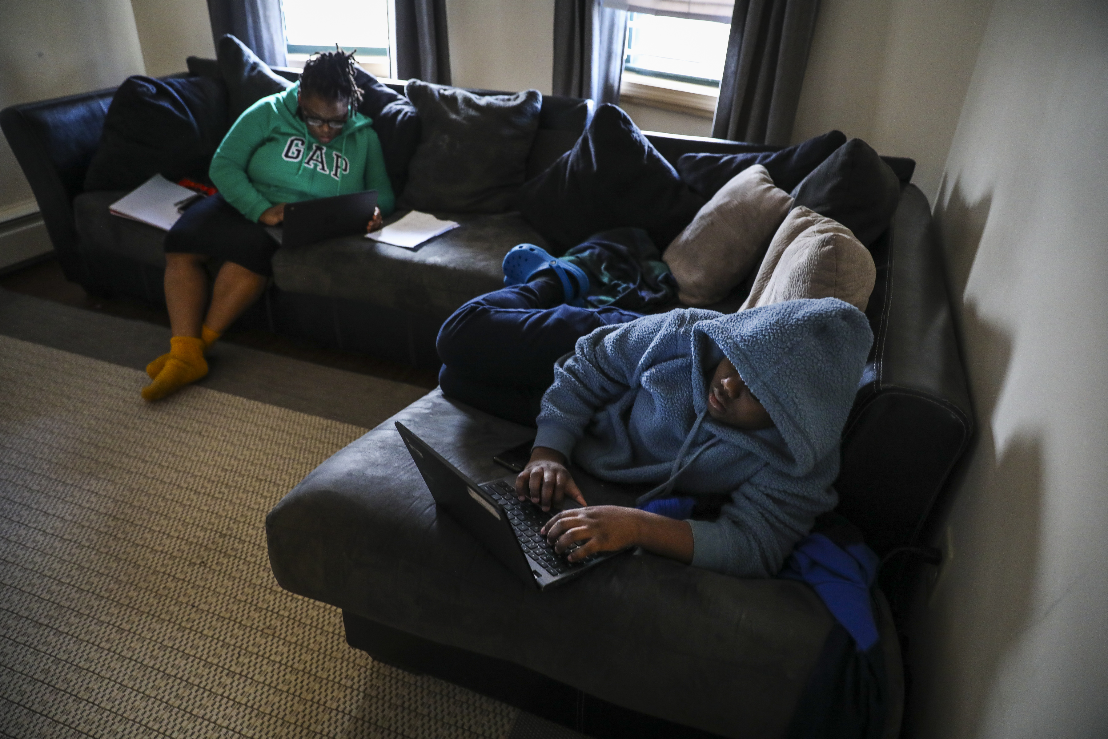 Sixth-grader Malaki Solo sat with his mom, Larae Robinson, last week while he worked on his homework in his family's home in Dorchester.