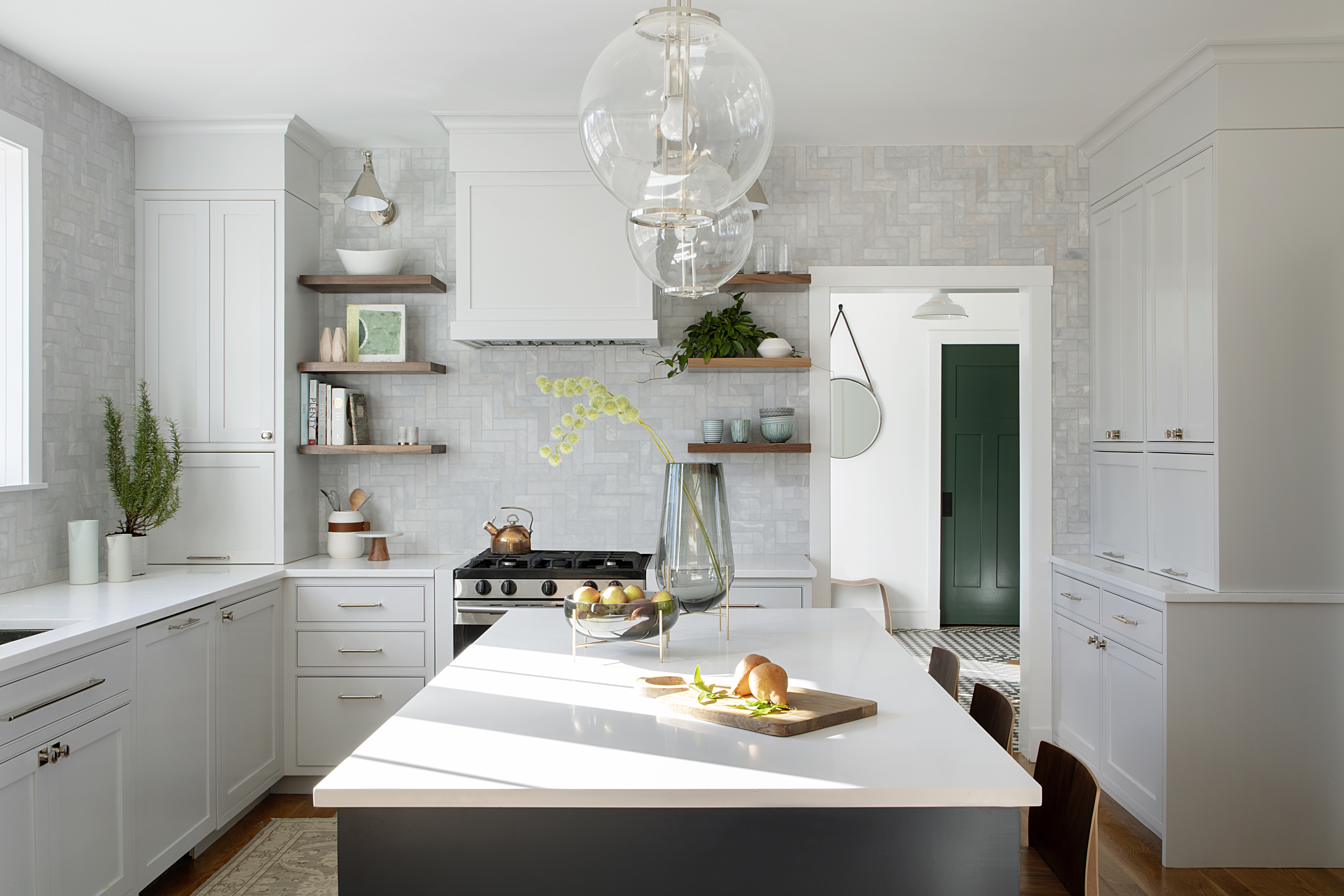 The Rejuvenation pendants and Visual Comfort sconces are polished nickel, while the lights in the living and dining rooms are brass. “The Midas touch feels more appropriate in the formal spaces,” says designer Sarah Scales.