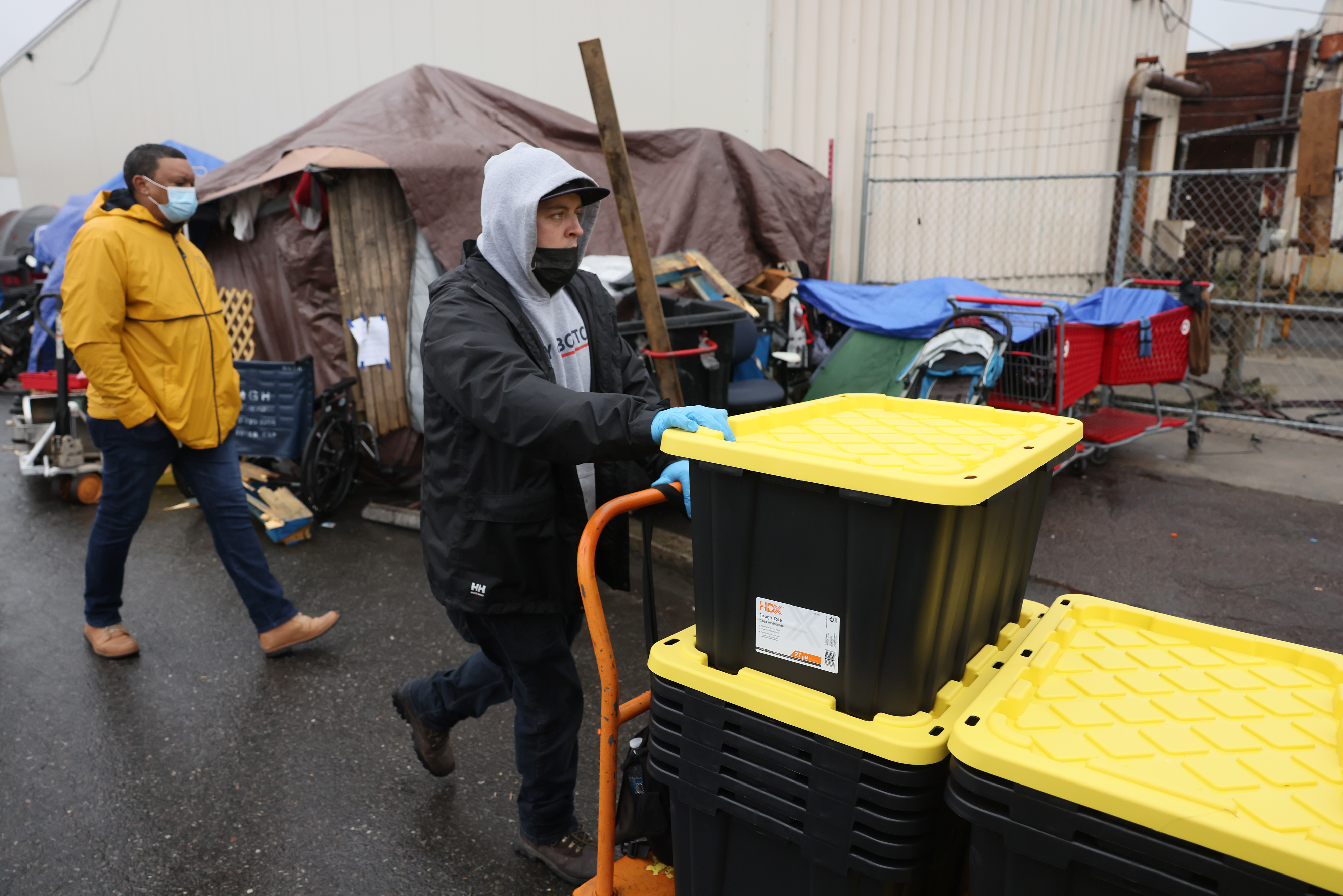 Workers rolled out bins on Monday to distribute to people who are living in tents along Southampton Streeet in Boston.