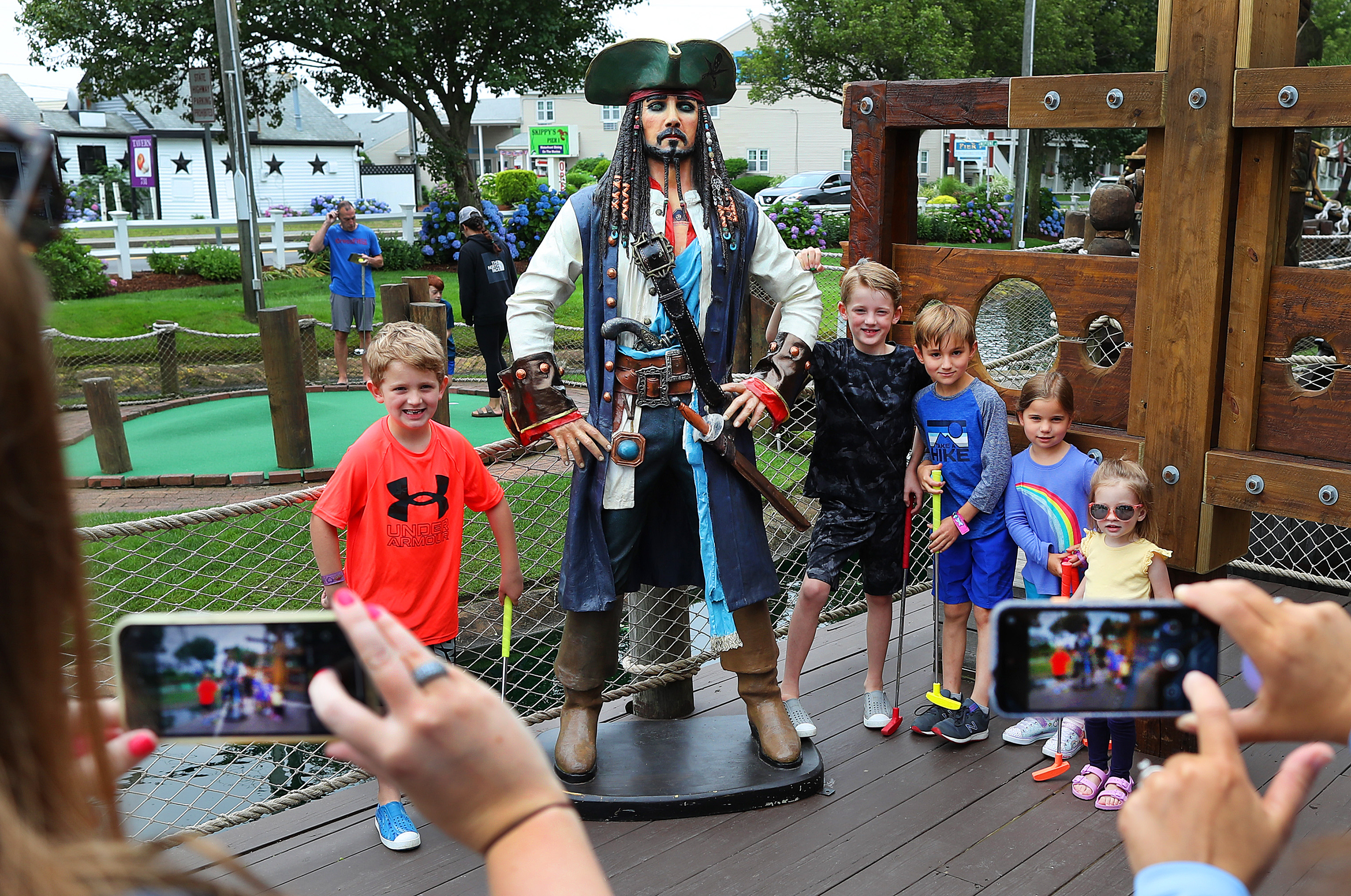 Children from Sudbury and Weymouth posed for a group photo by their parents at a pirate statue at Pirate’s Cove miniature golf course in South Yarmouth.