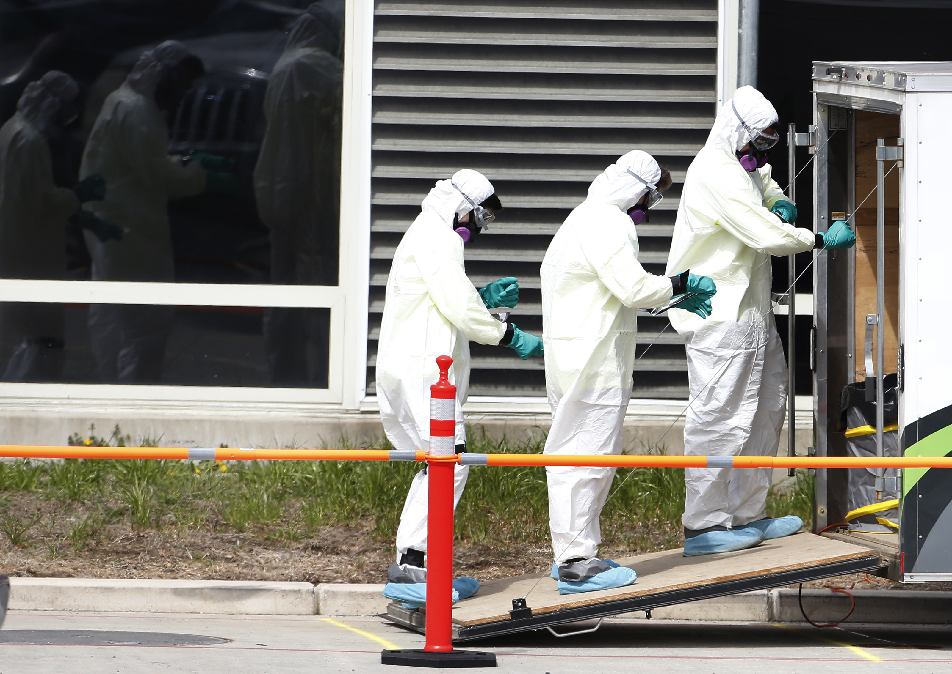 Holyoke, MA - 3/31/20 -  Cleaners unwrap their protective gear as they leave the Soldiers' Home in Holyoke where several people have died due to coronavirus or COVID-19.  (Jessica Rinaldi/Globe Staff)