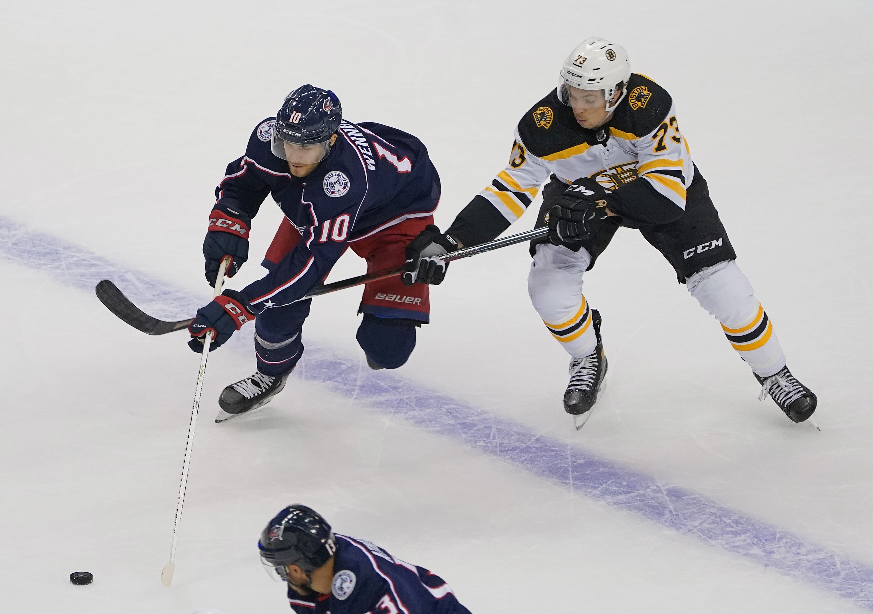 Charlie McAvoy slows up Alexander Wennberg of Columbus during the third period of Thursday's game.