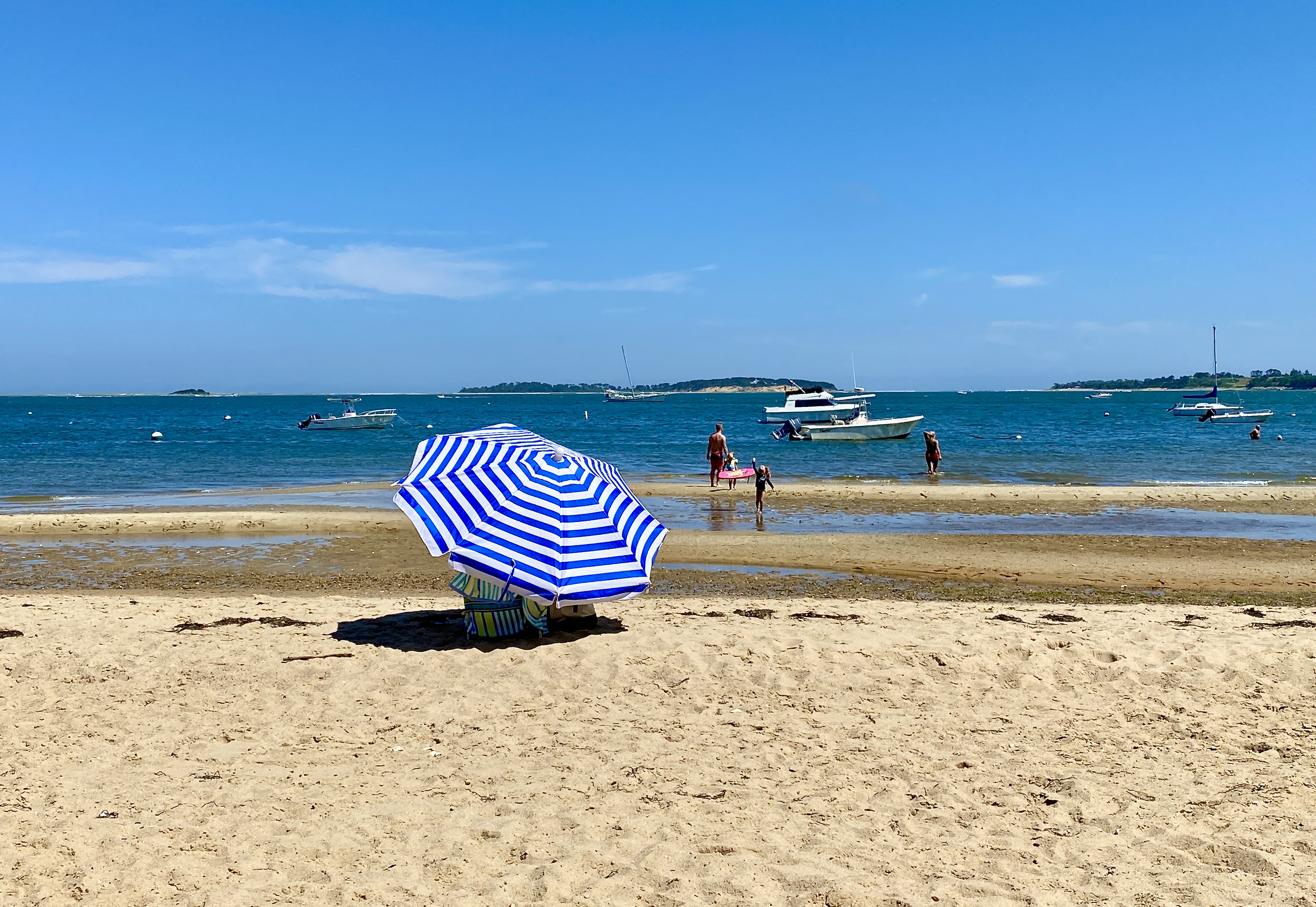 A woman shields herself from the sun at South Orleans Beach on Pleasant Bay in Orleans.