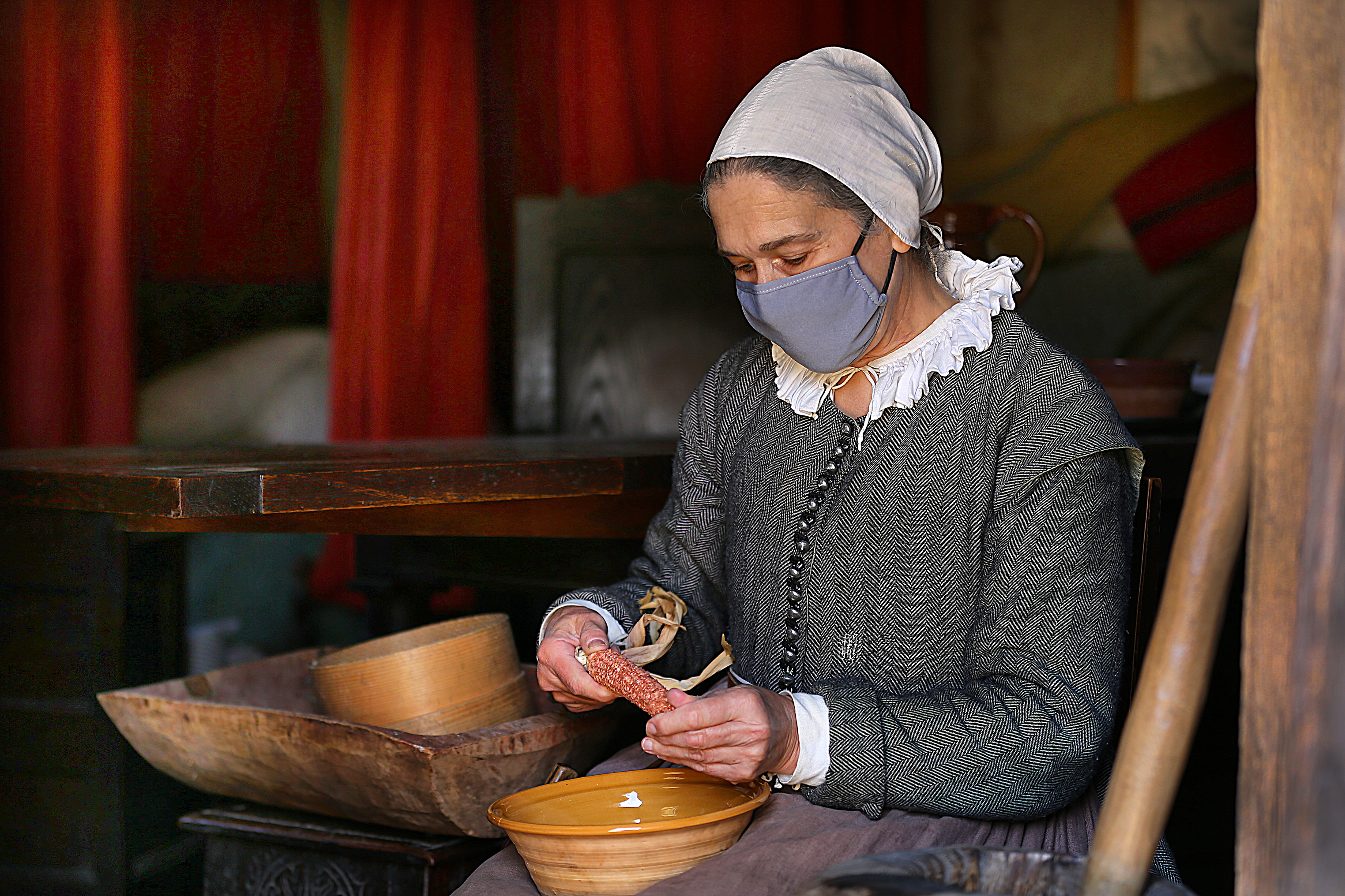 Kathleen Wall, who portrays Zara Godbertson, removes corn kernels in her home in Pilgrim Village.