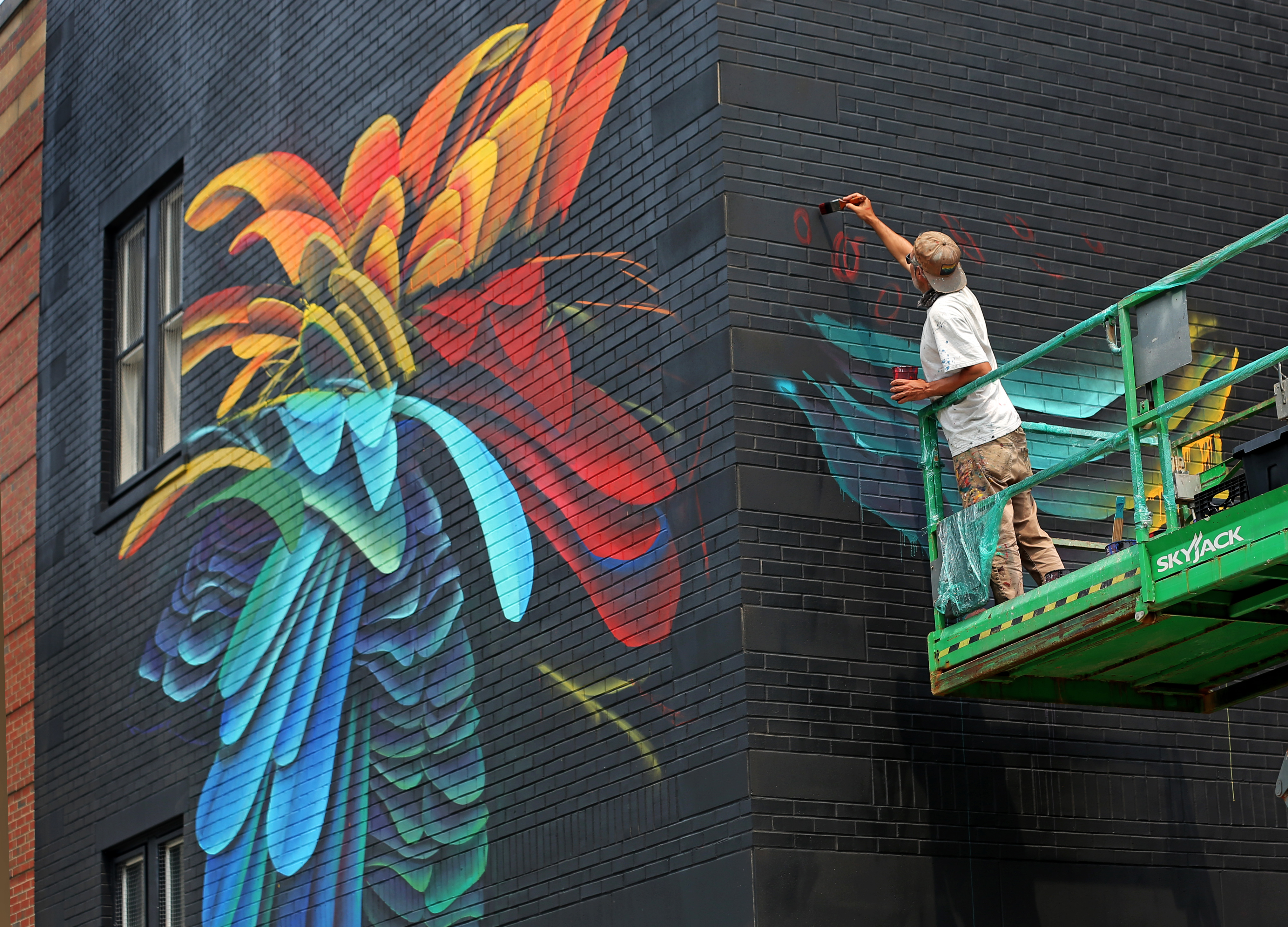 Felipe Ortiz worked on the details of his mural on Gove Street.