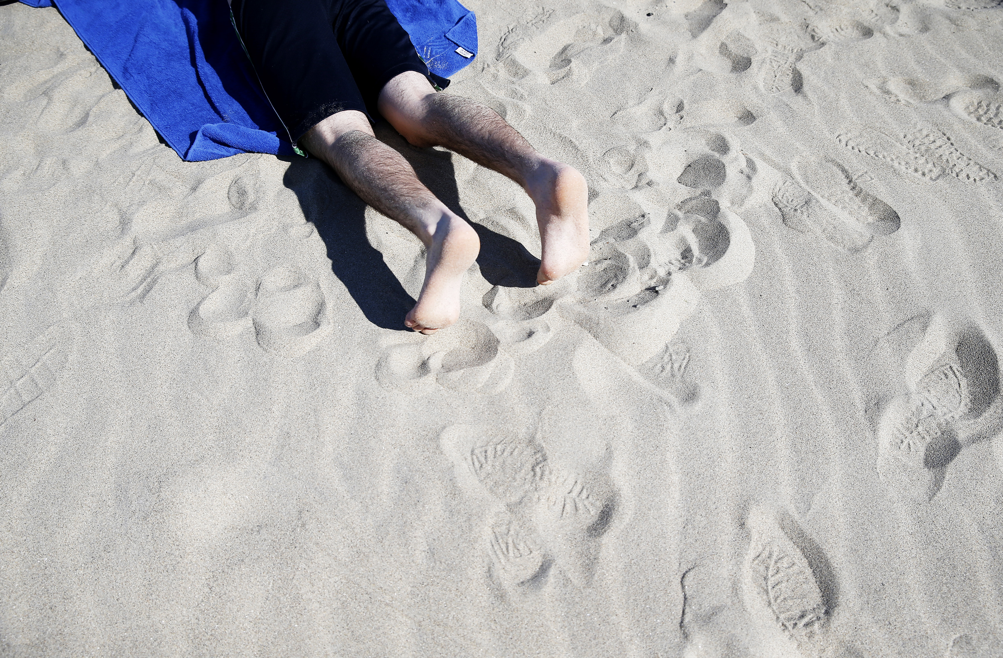 Ori Steinfink, of Brookline, soaked up the sunshine on Revere Beach as temperatures reach into the 70s on March 9.