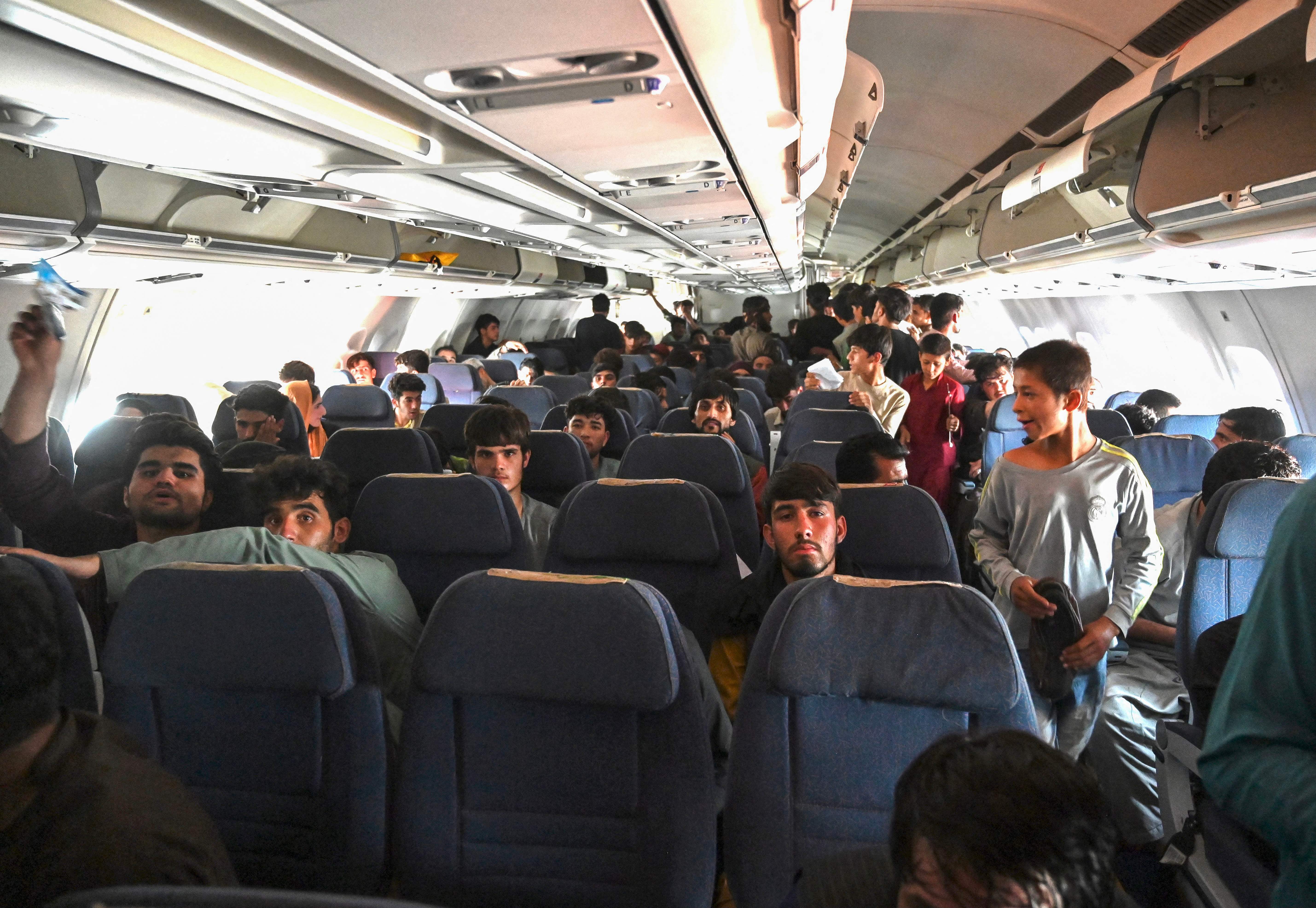 Afghan passengers sat inside a plane.
