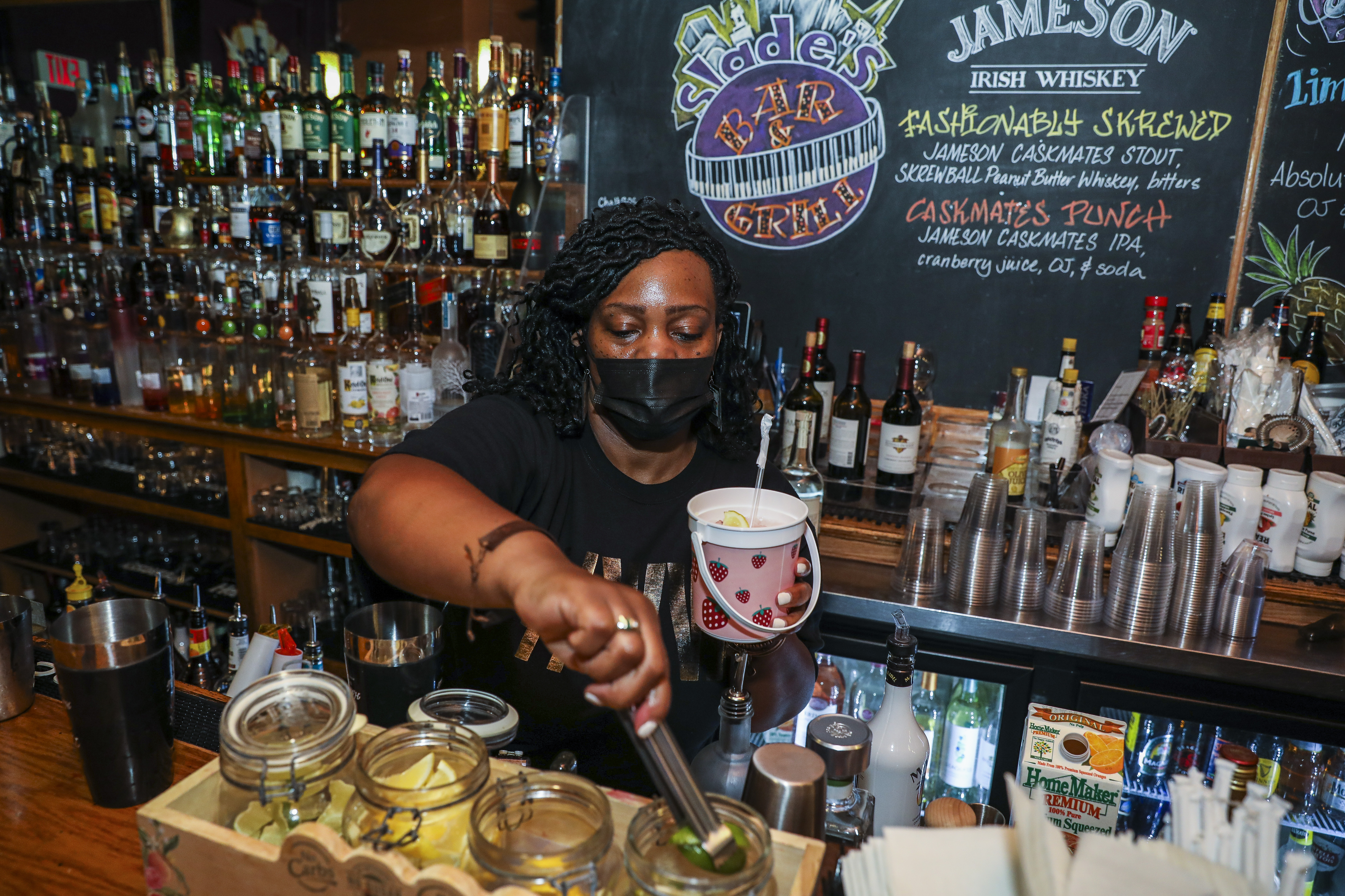 Bartender Stephanie Holloway creates a rum drink in a bucket on a recent Friday night at Slade's.